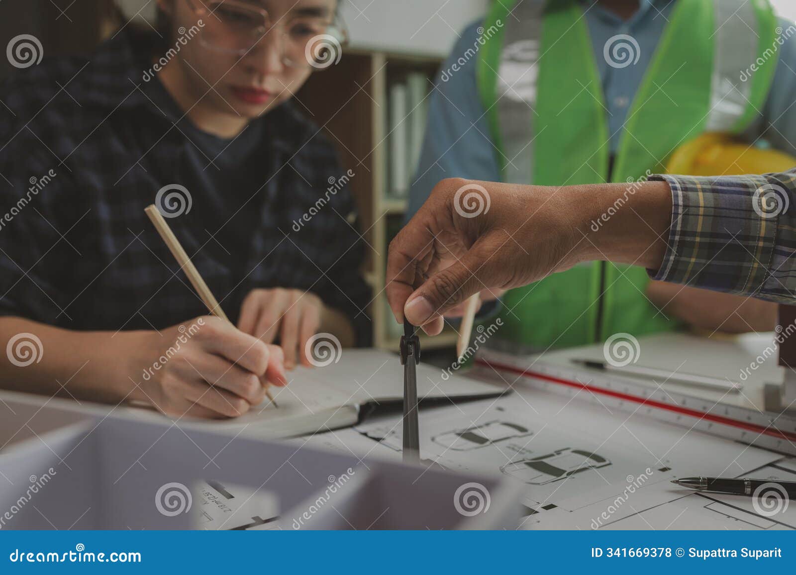 a team of engineers meets in the office to analyze the  structure to ensure it meets the client's wants. a team of