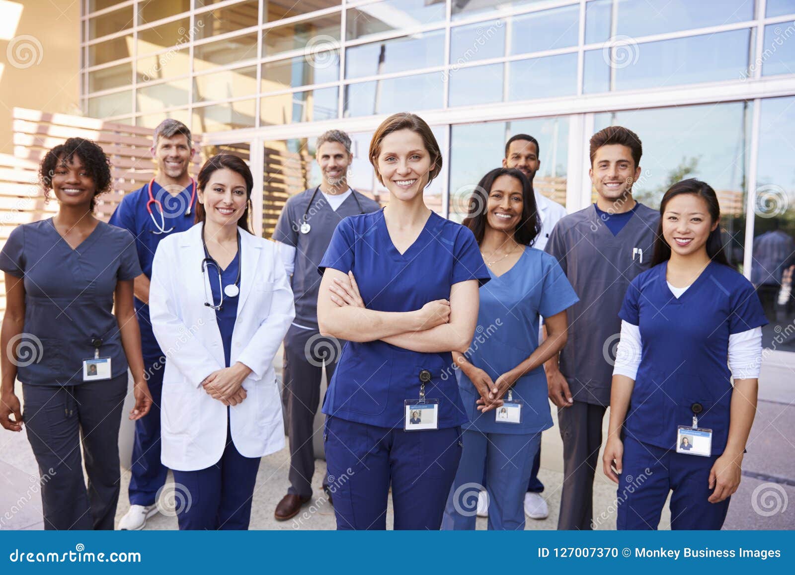 team of healthcare workers with id badges outside hospital