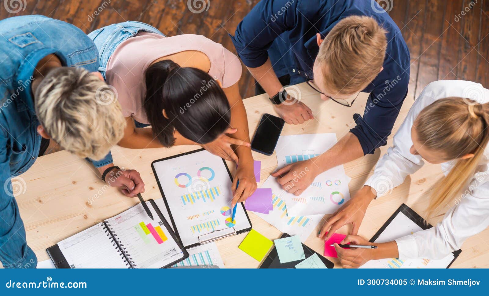 team of young and confident startupers is working at the table in the office, discussing the strategy and development