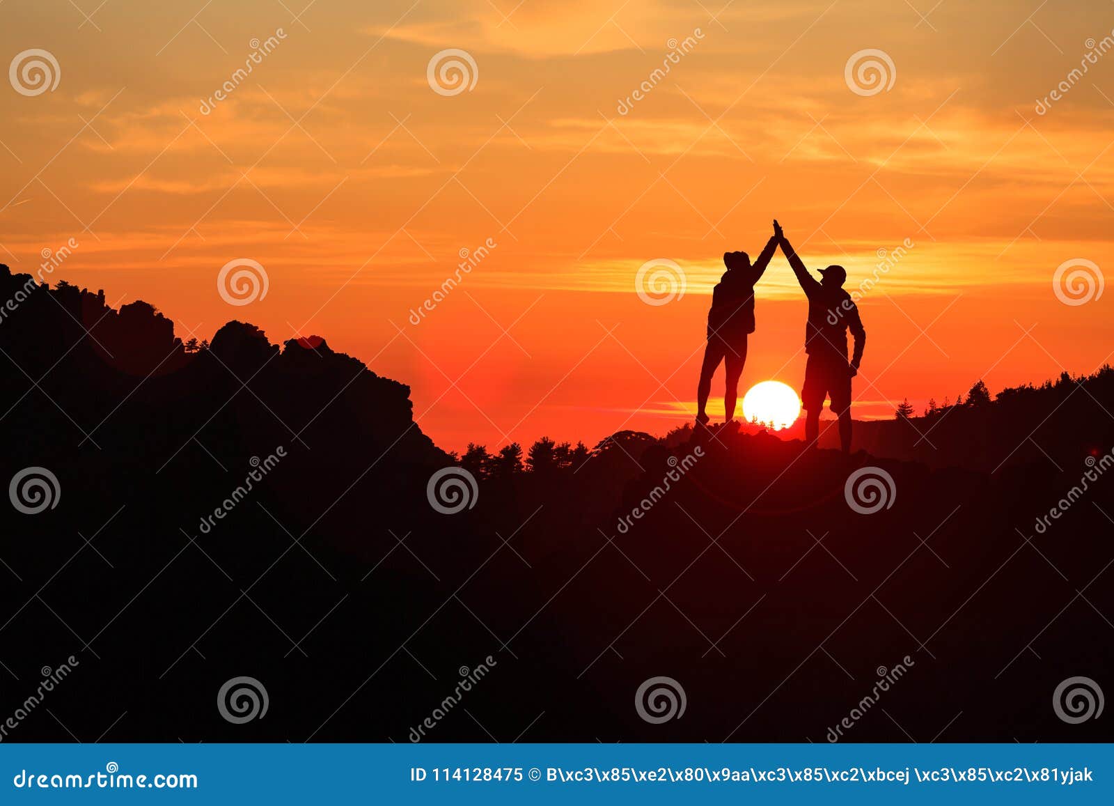 teamwork couple celebrating in inspiring mountains sunset