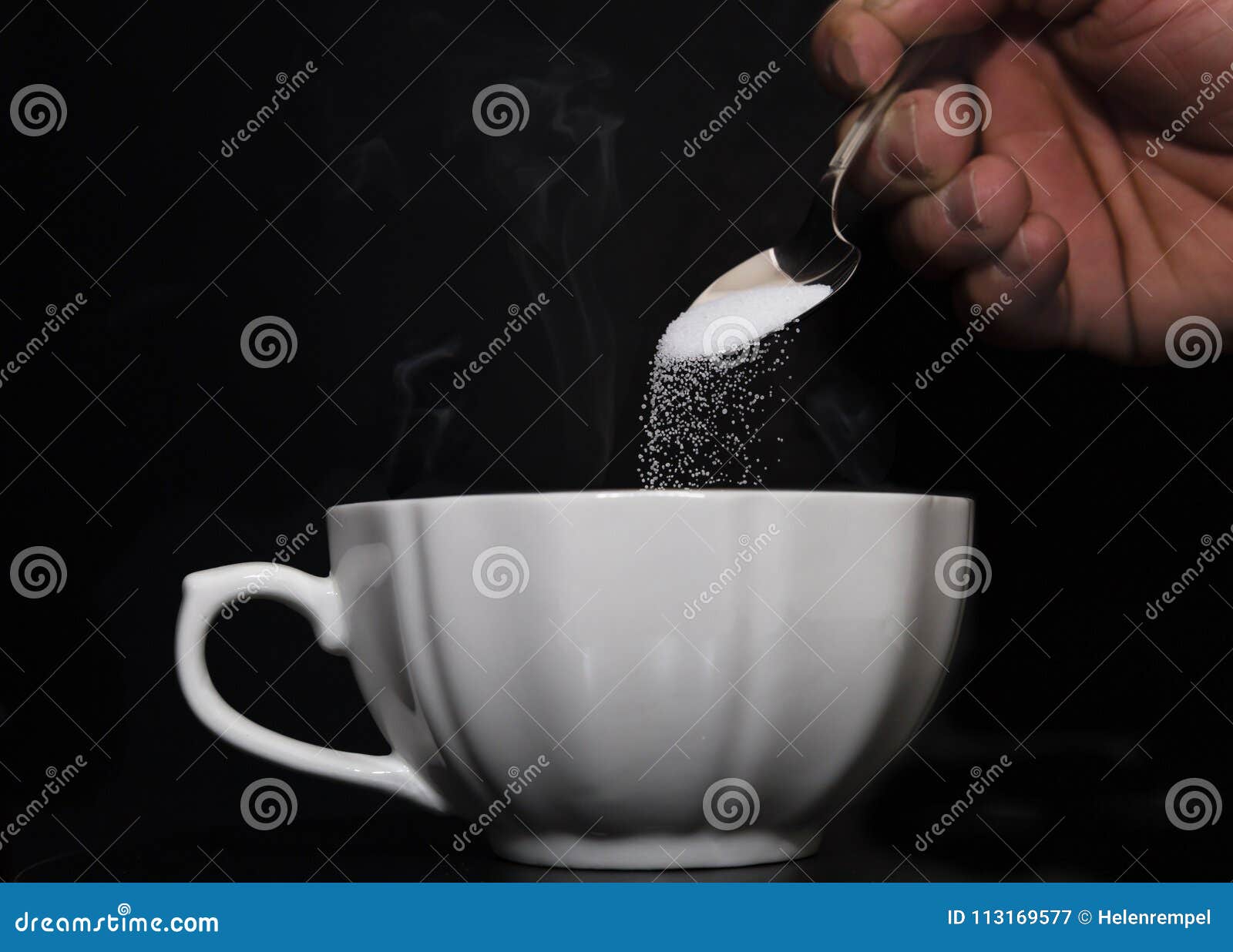 Teaspoon of Sugar Being Poured into Hot Cup of Coffee Stock Image