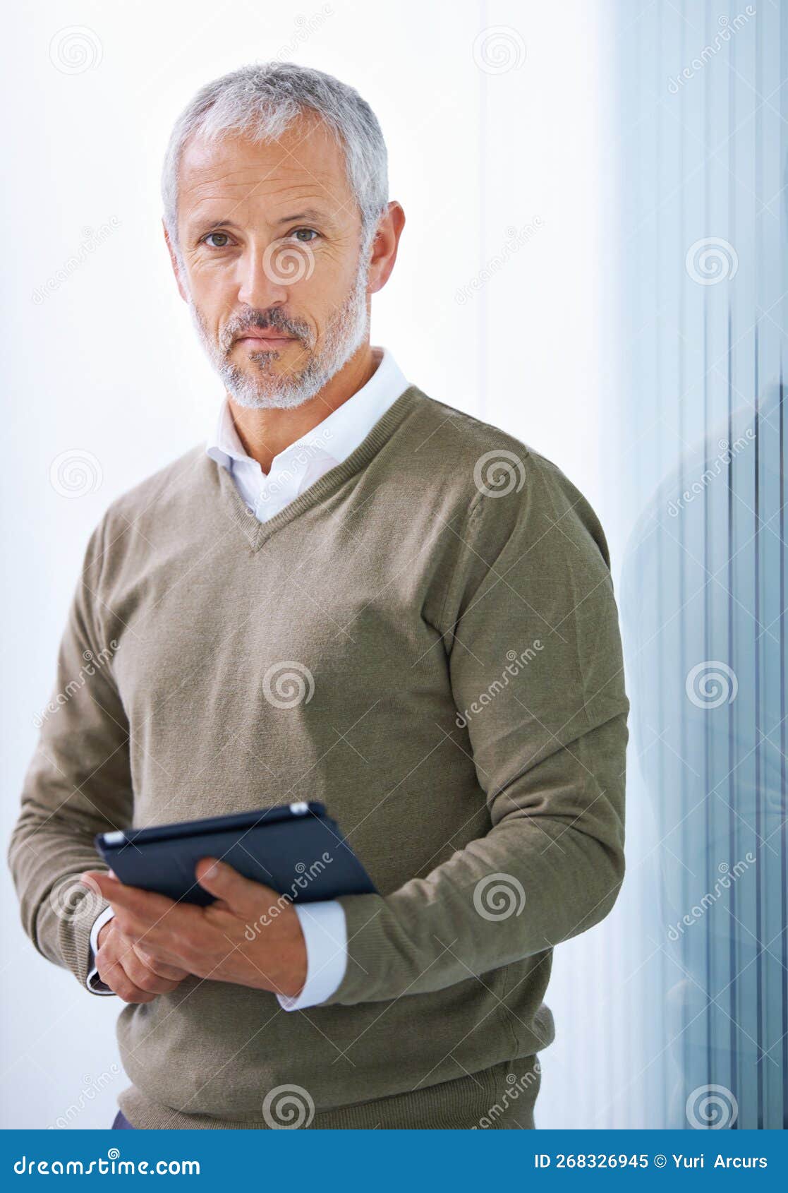 tech for the modern exec. portrait of a mature businessman standing with a digital tablet.