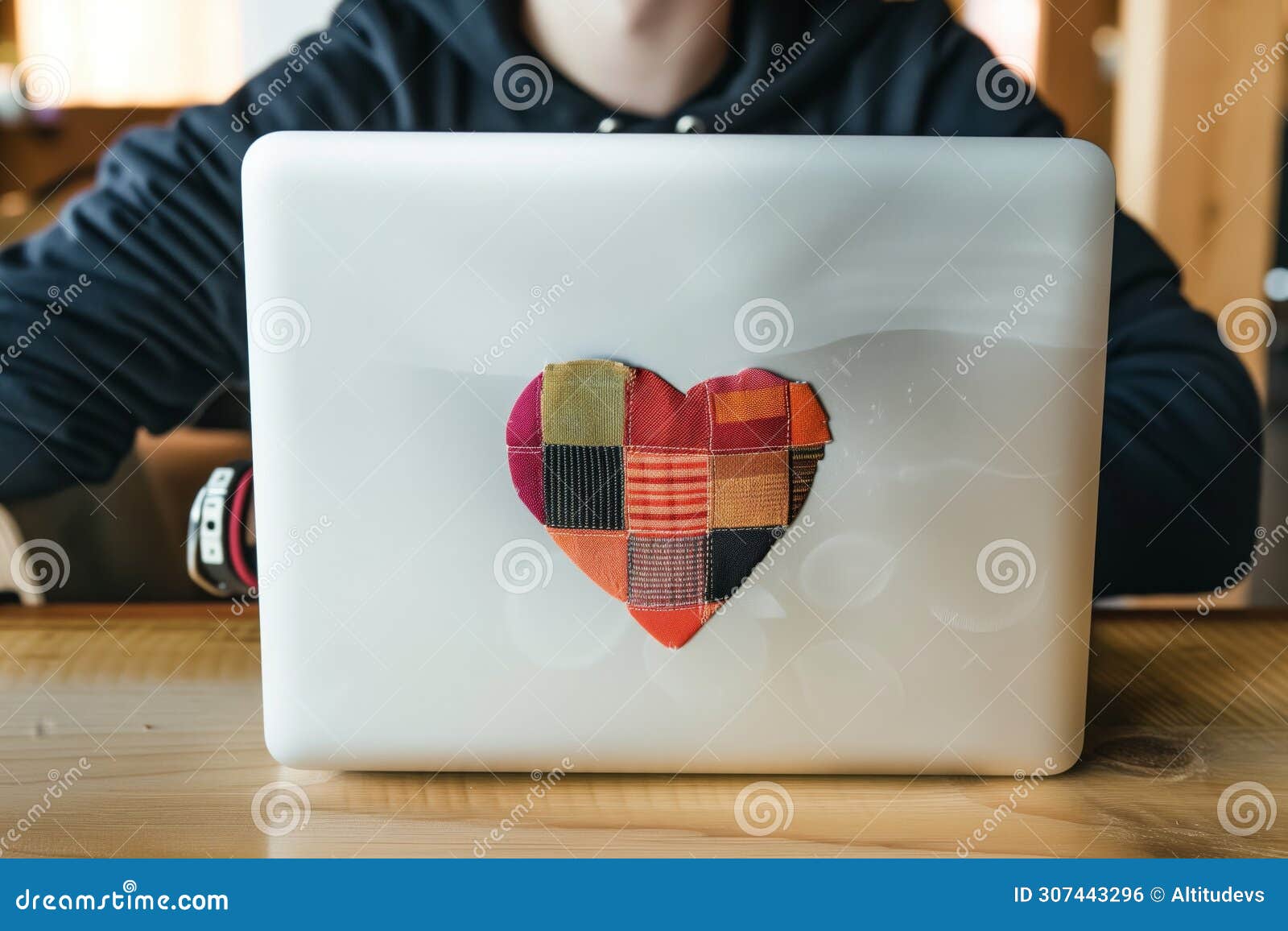 a techie with a laptop sticker in the  of a patchwork heart