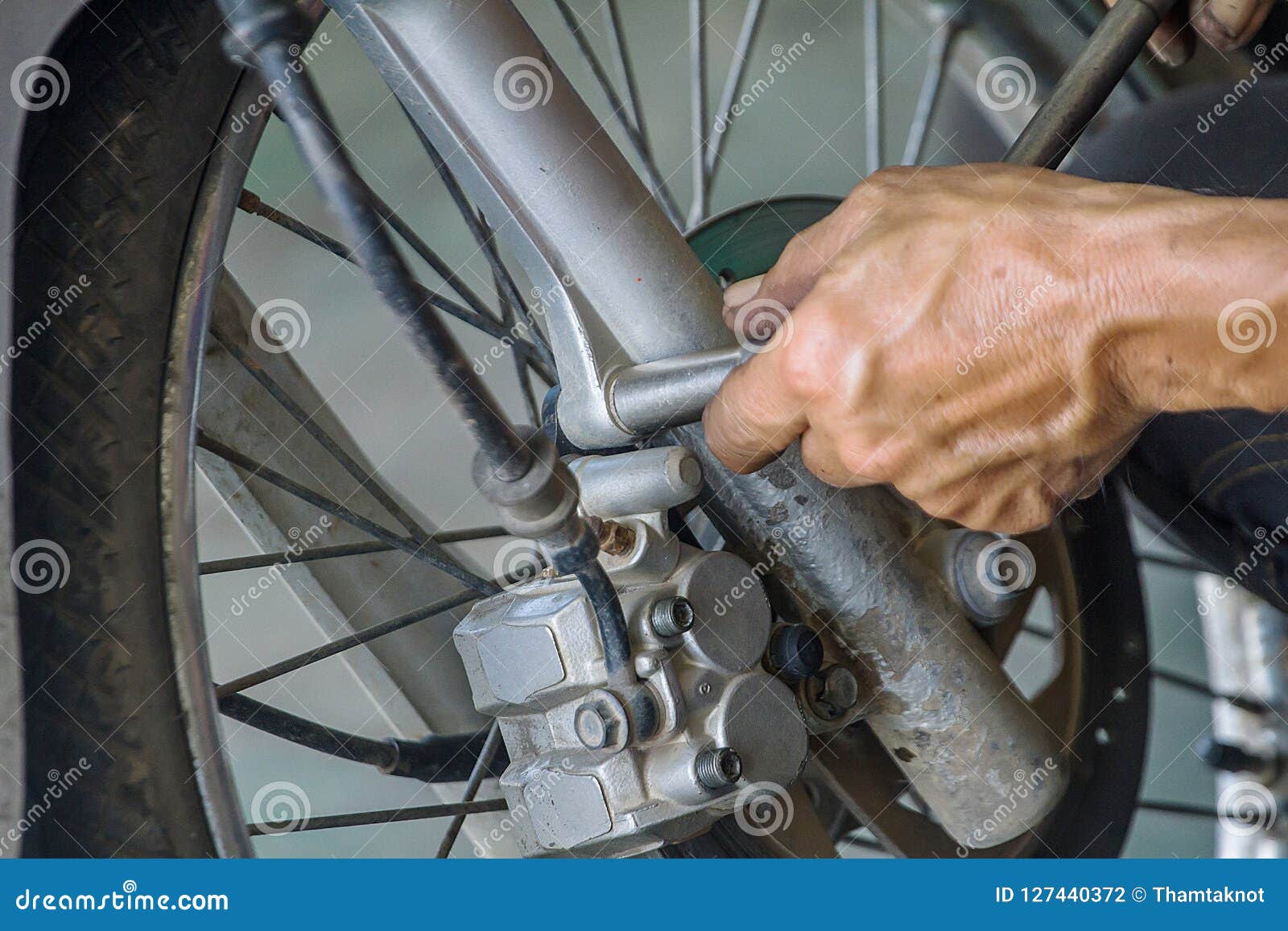 The Technician are Changing Brake Pad of Motorcycle. Stock Photo