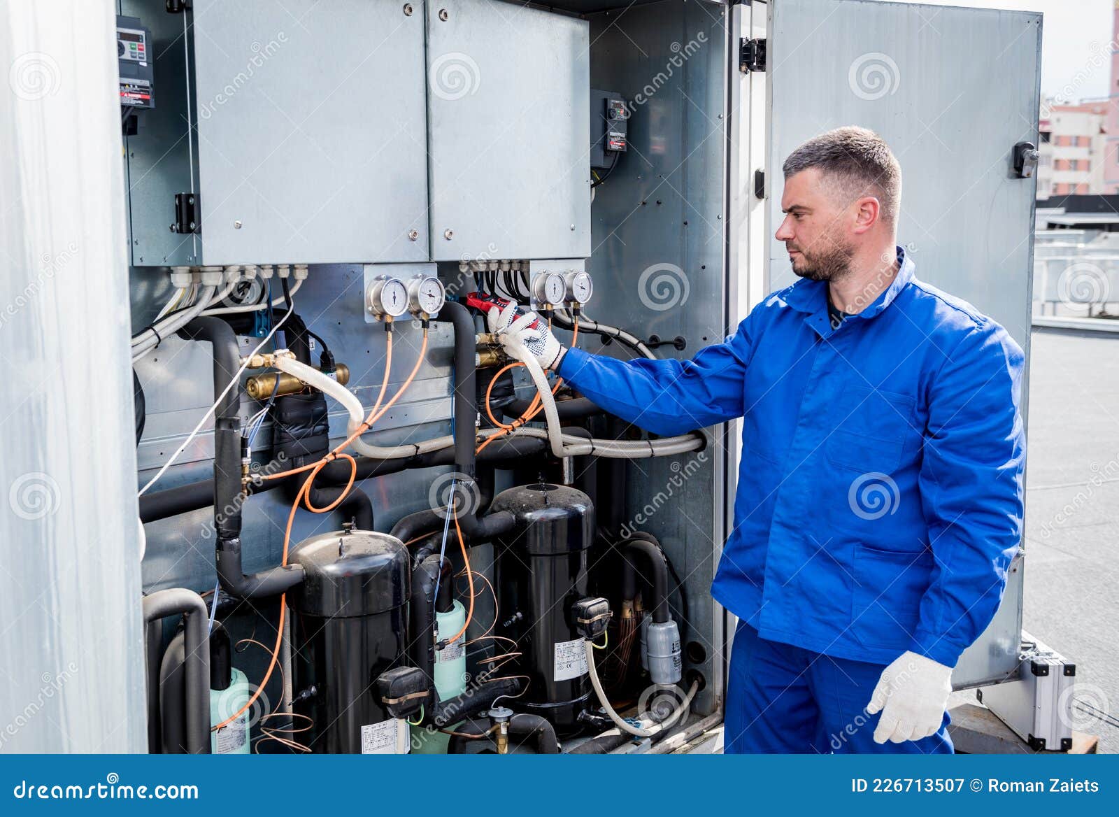 The Technician Checking Power Lines of the Heat Exchanger with Current
