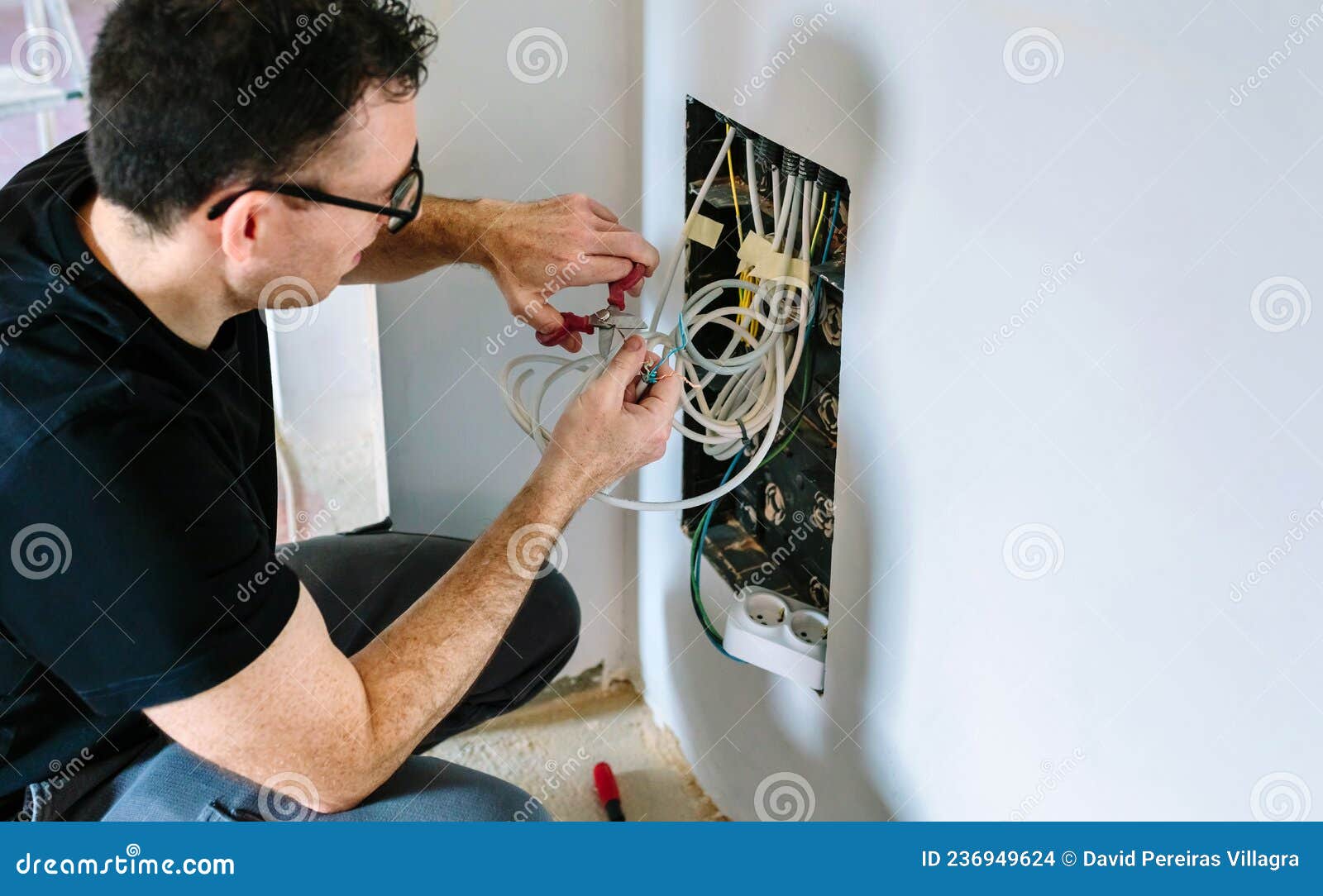 Technician Cutting Cable To Install Box Stock Photo