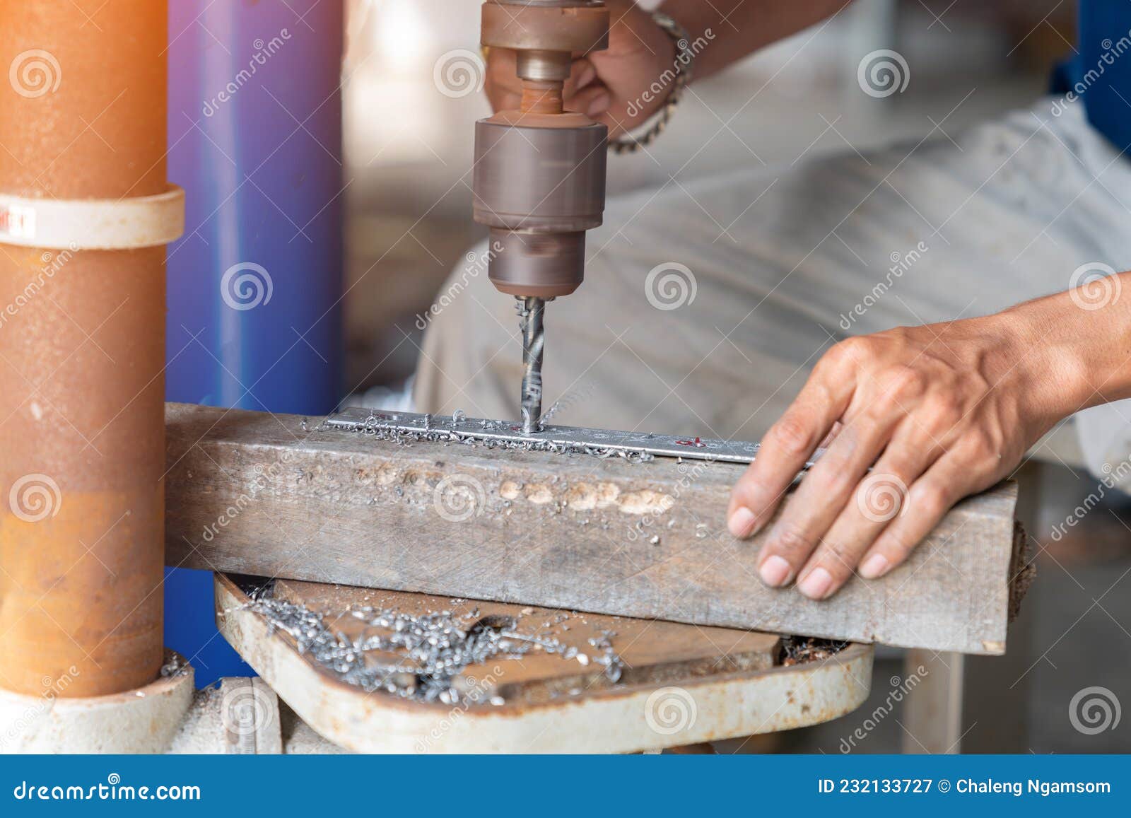 Technician Drills a Hole in Angle Iron for Support Pipe Stock Image