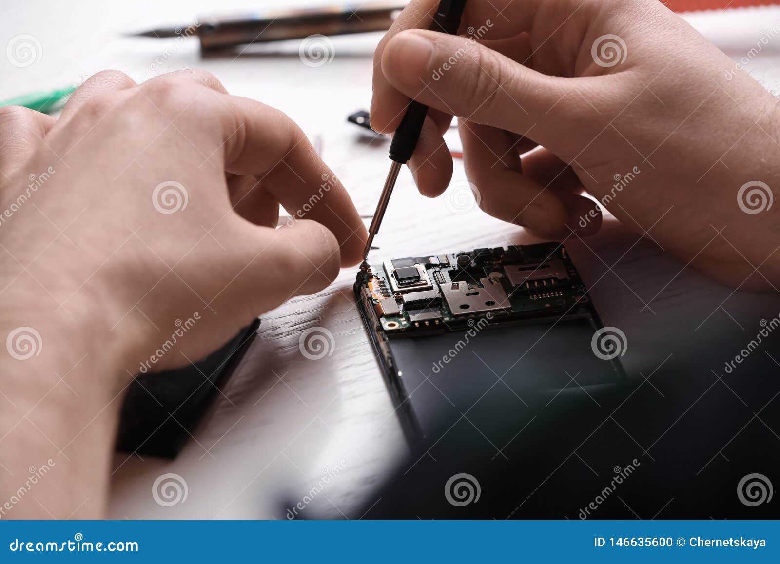 Technician Fixing Mobile Phone at Table. Device Repair Service Stock