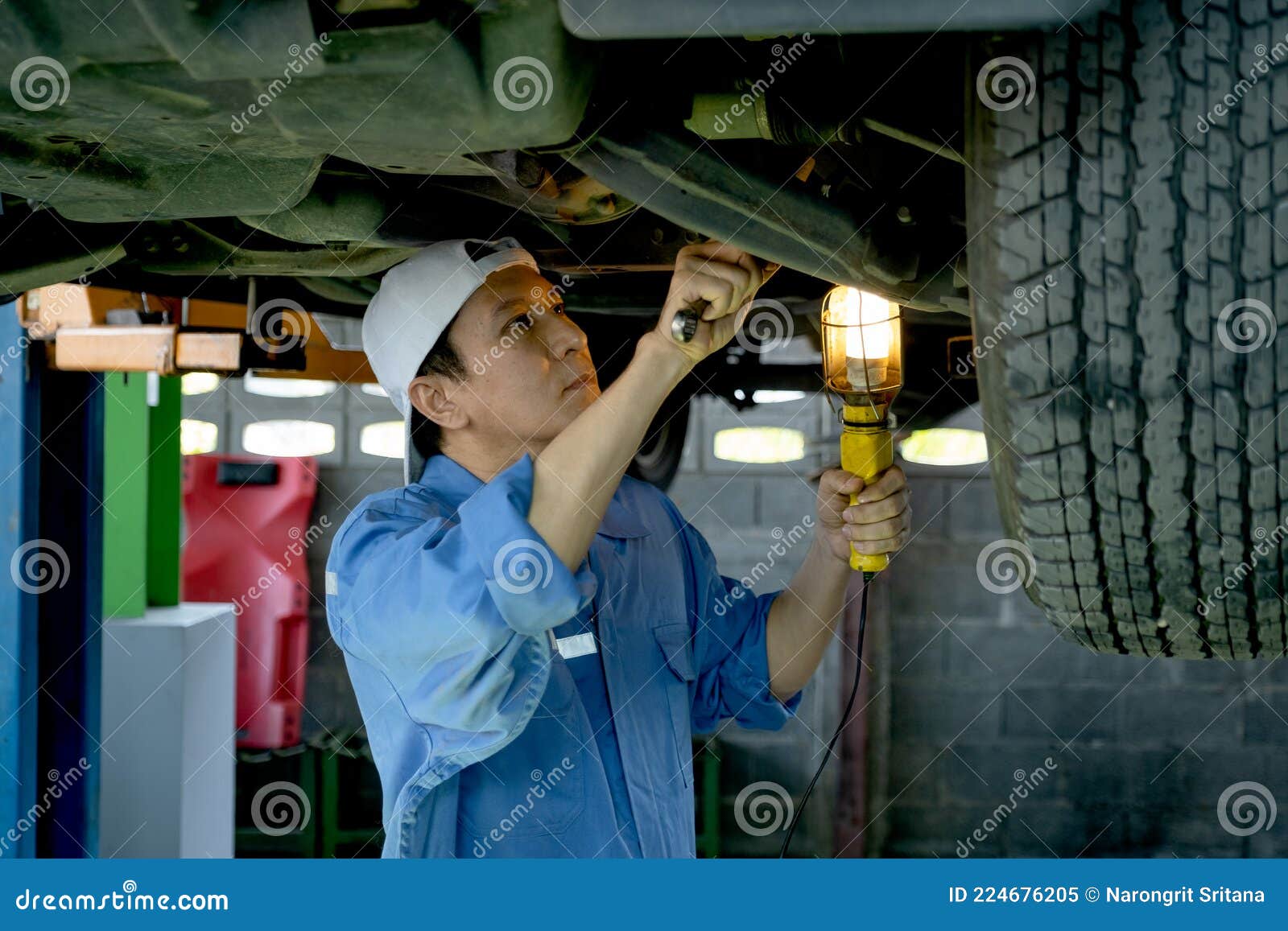 Technician or Garage Worker Stand and Work Under the Car and Use
