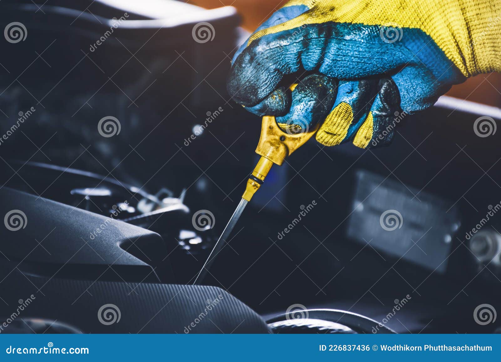 Technician Hand Pulling Oil Dipstick for Checking Lubricating Oil Level