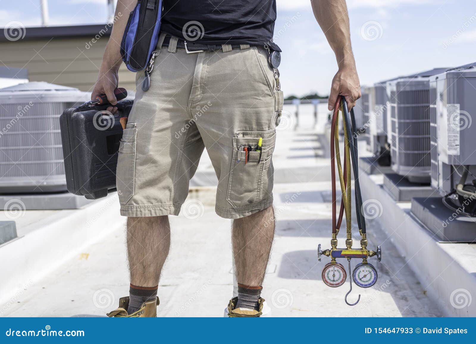 technician with hvac tools on roof