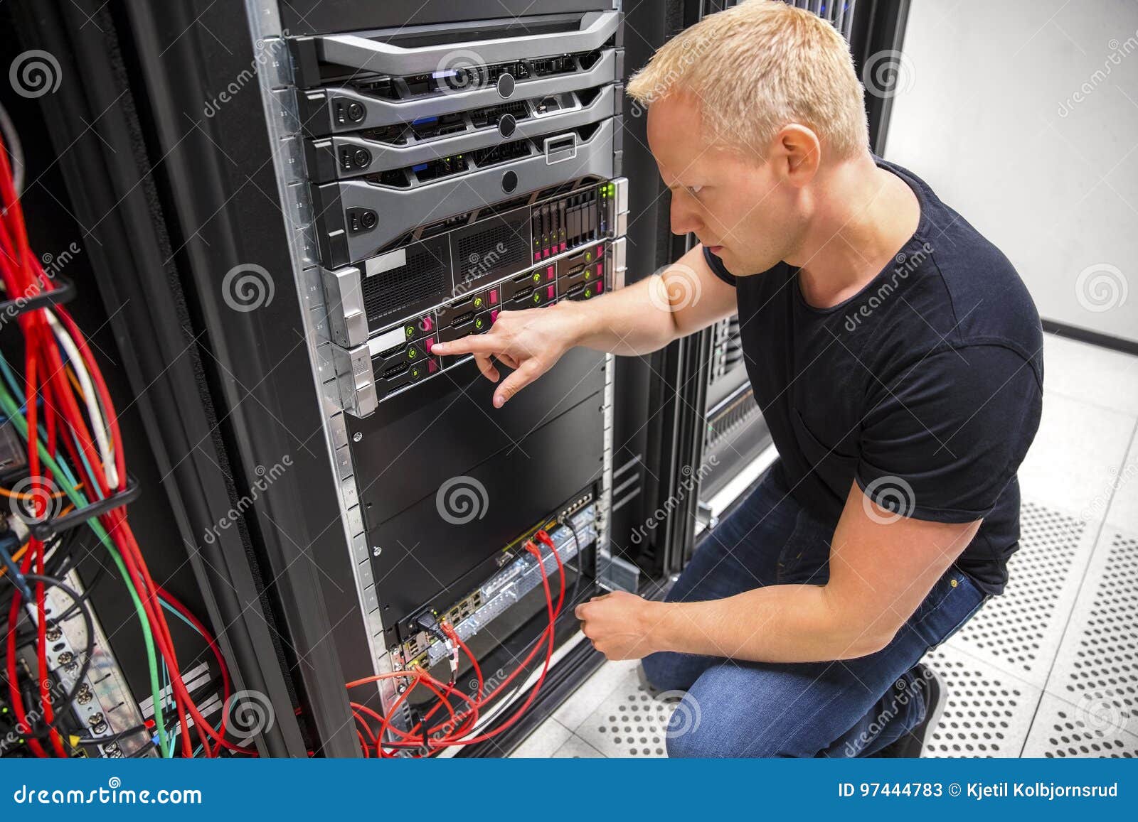 it technician monitors server on rack in datacenter