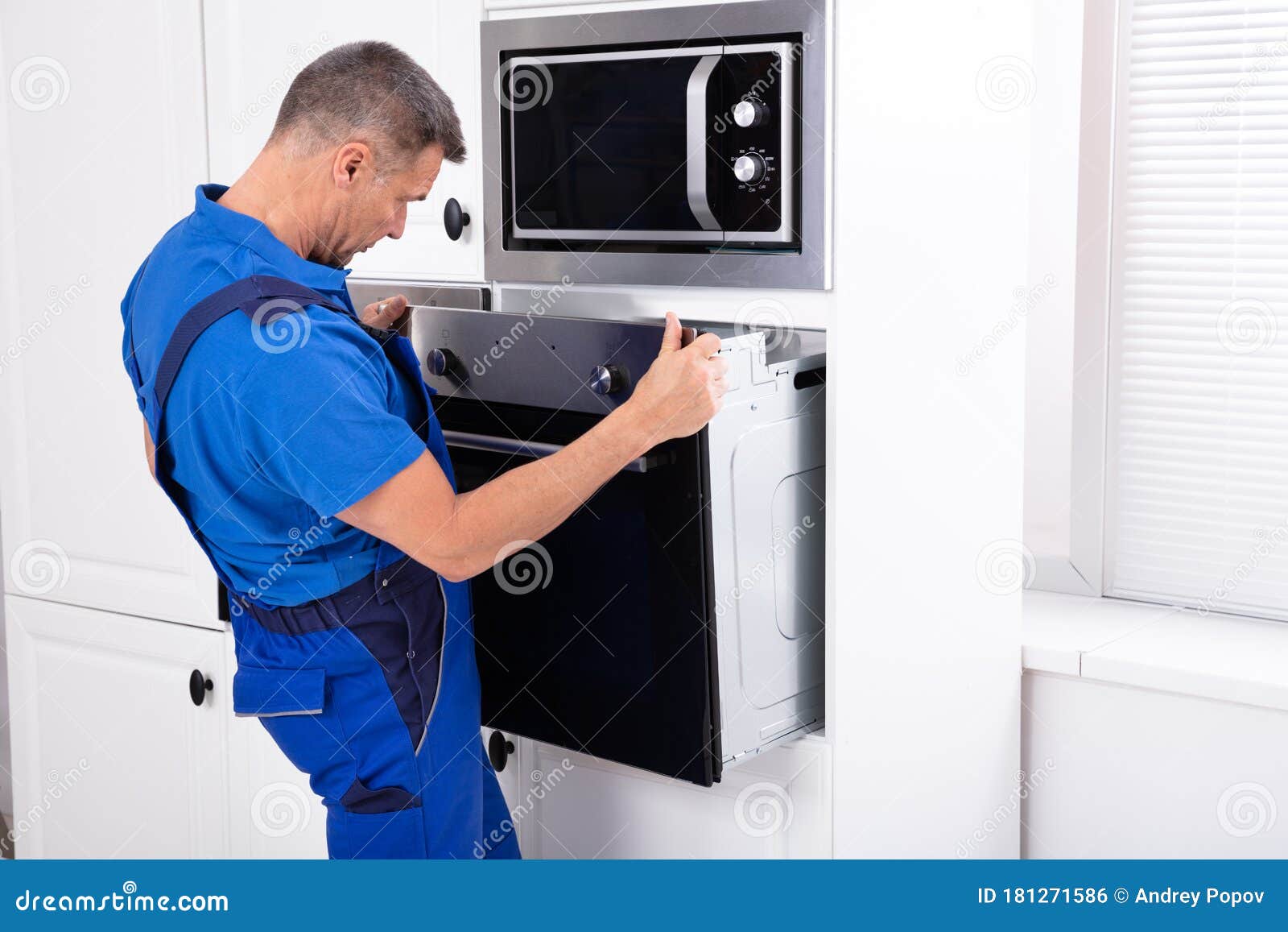 Technician in Overall Installing Oven Stock Photo Image of closeup