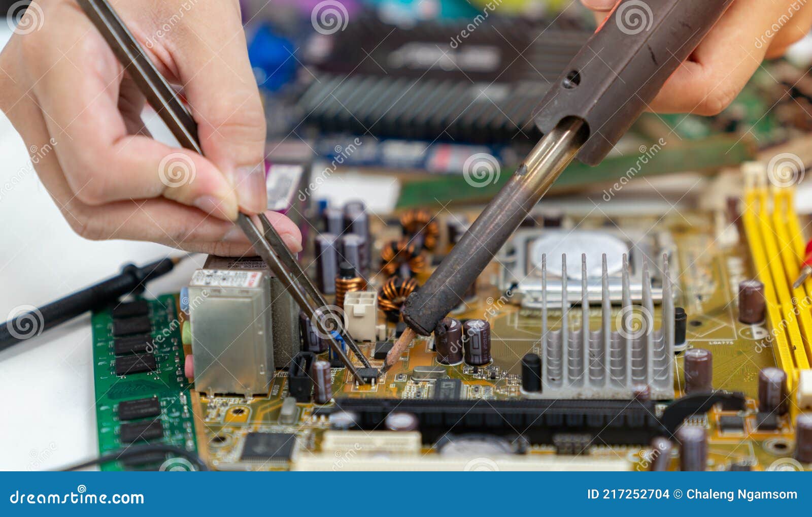 Technician Repairing Inside of Mother Board by Soldering Iron Stock