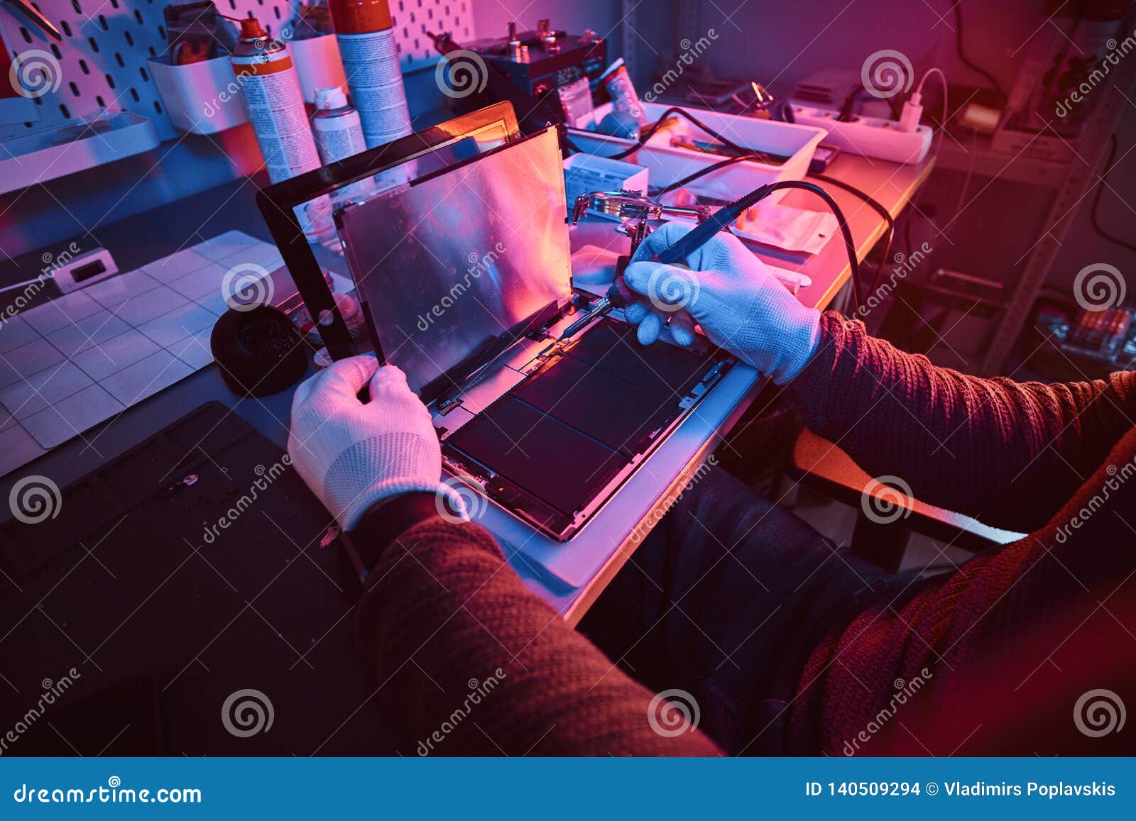 The Technician Repairs a Broken Tablet Computer in a Repair Shop