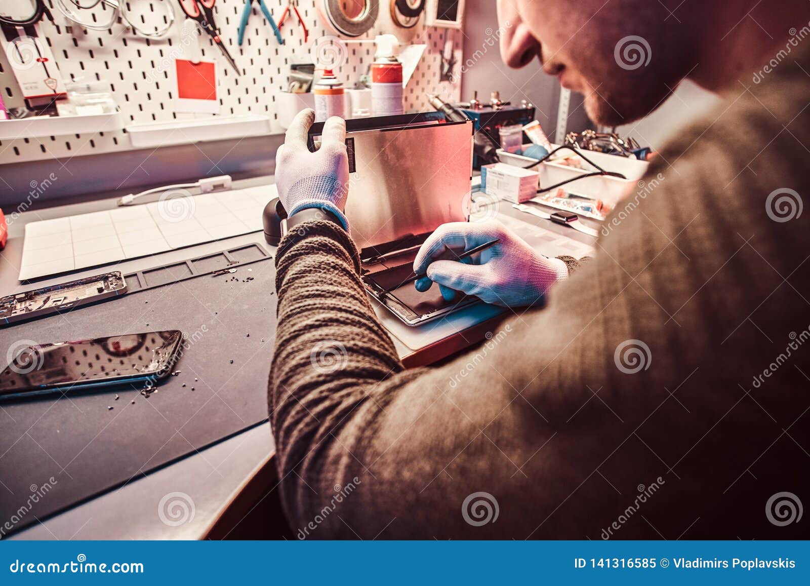 The Technician Repairs a Broken Tablet Computer in a Repair Shop Stock