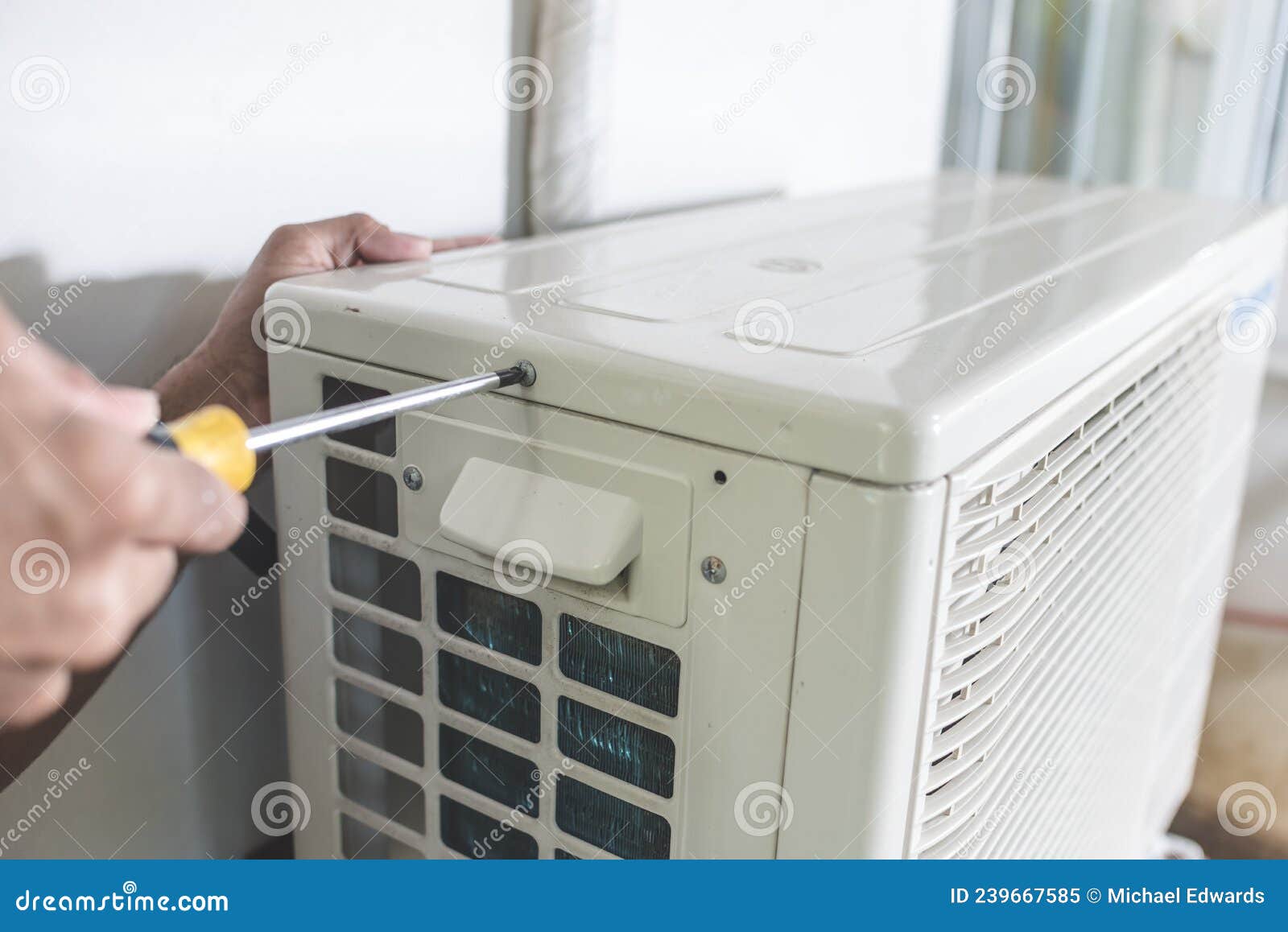 A Technician Unscrews the Top Hatch of the Outdoor Compressor Unit of a