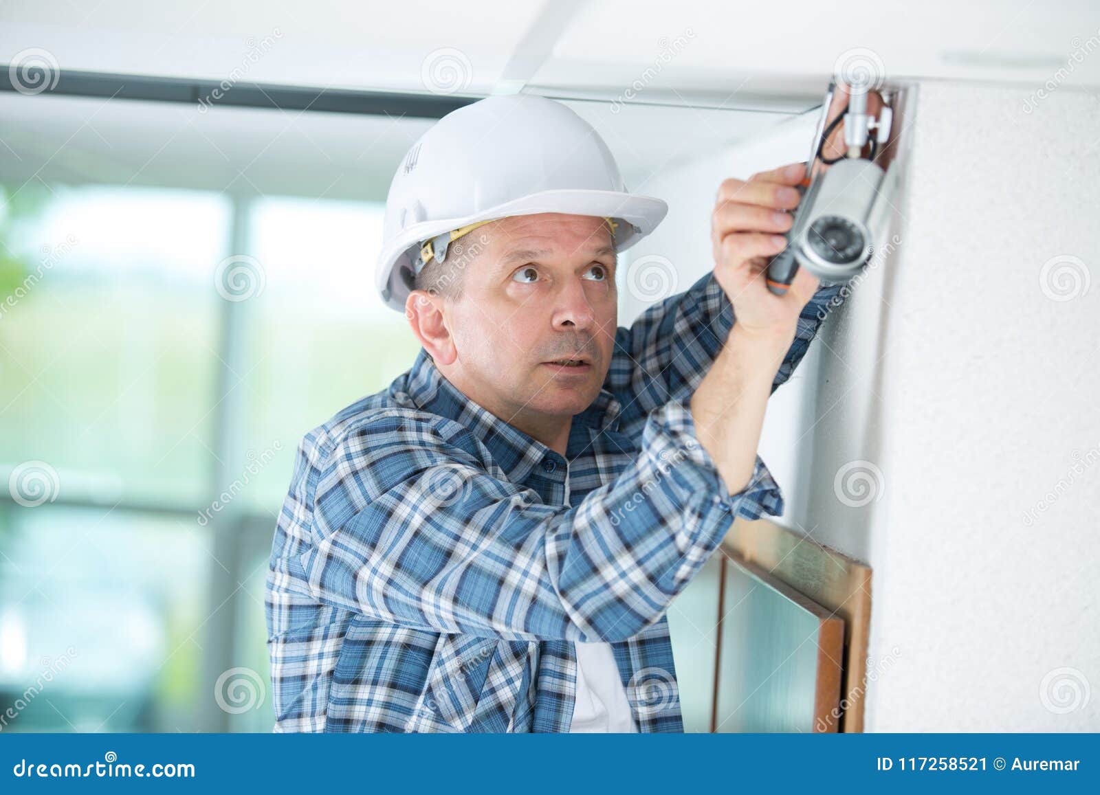 Technician Worker Installing Video Surveillance Camera on Wall Stock