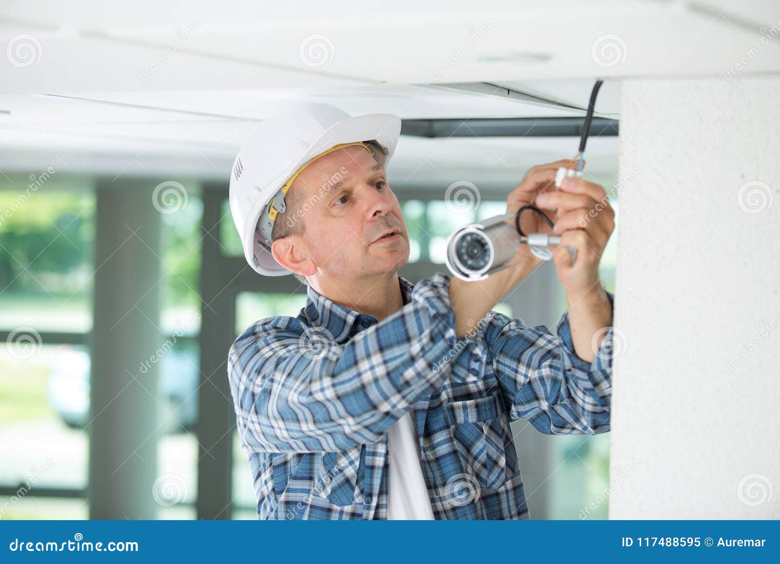 Technician Worker Installing Video Surveillance Camera on Wall Stock