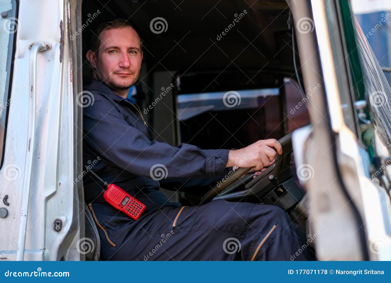 Technician or Worker Sit on Driver Seat and Look To the Camera in Cargo