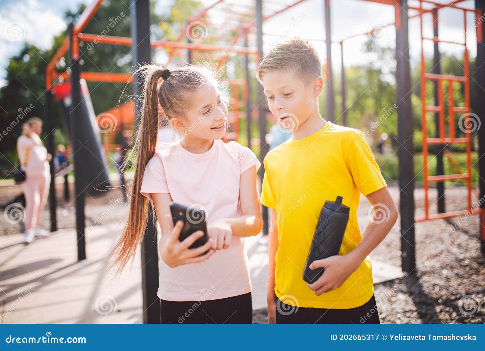 Technology And Sport For Children Two Teenage Kids Using Smartphone And Online Workout App Twins Boy And Girl Watching Video On Stock Image Image Of Athletic Heterosexual