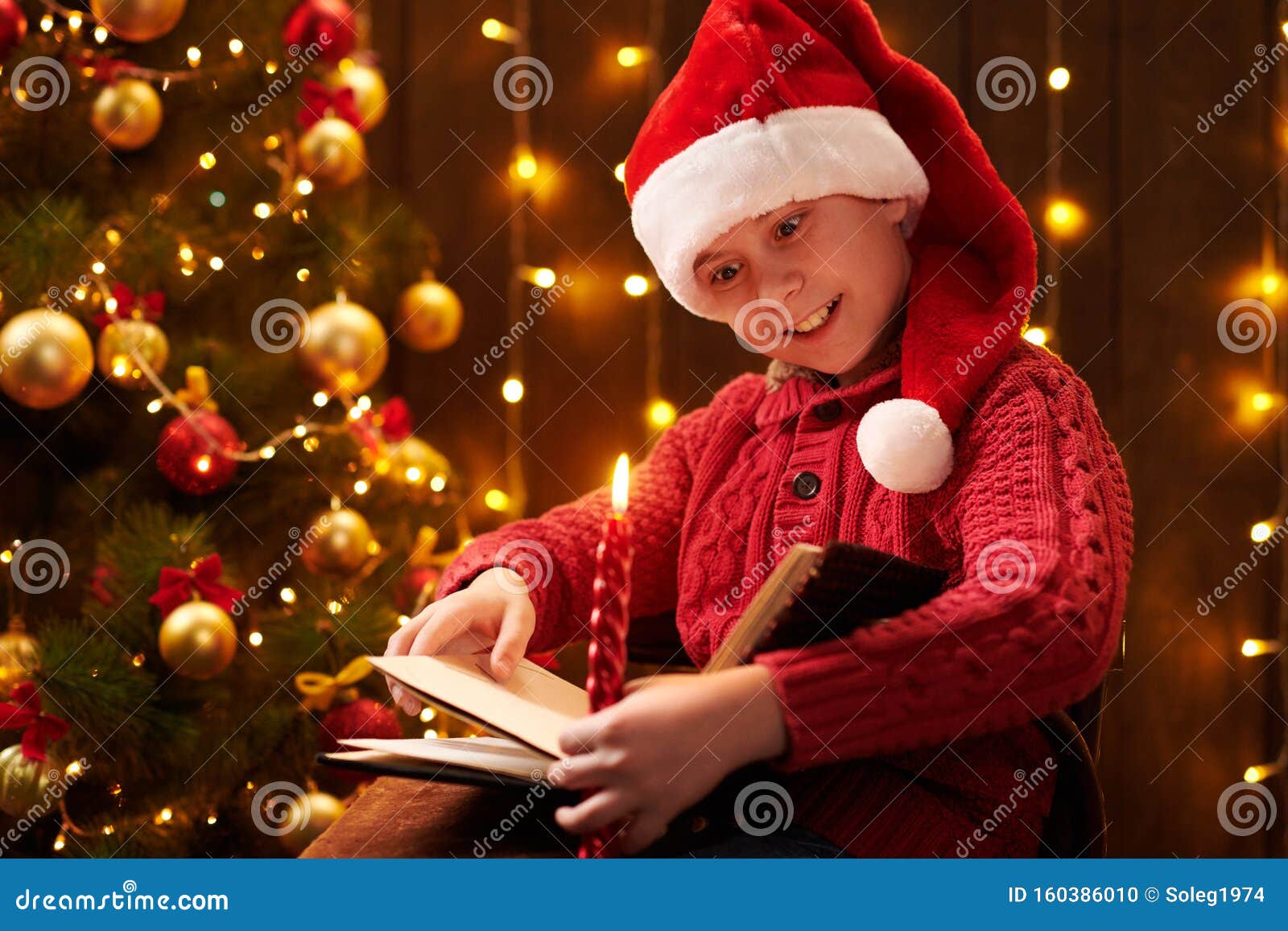 Teen Boy Reading Book Sitting Indoor Near Decorated Xmas Tree With