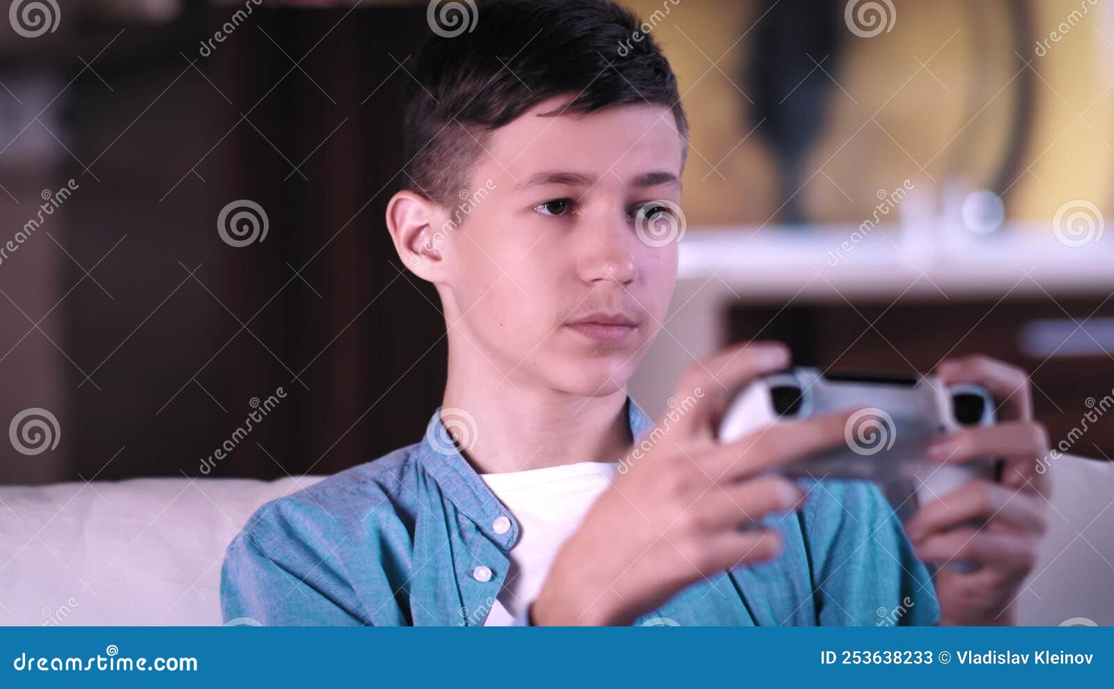 Serious Teen Boy Sitting on the Sofa and Plays a Game on a Console ...
