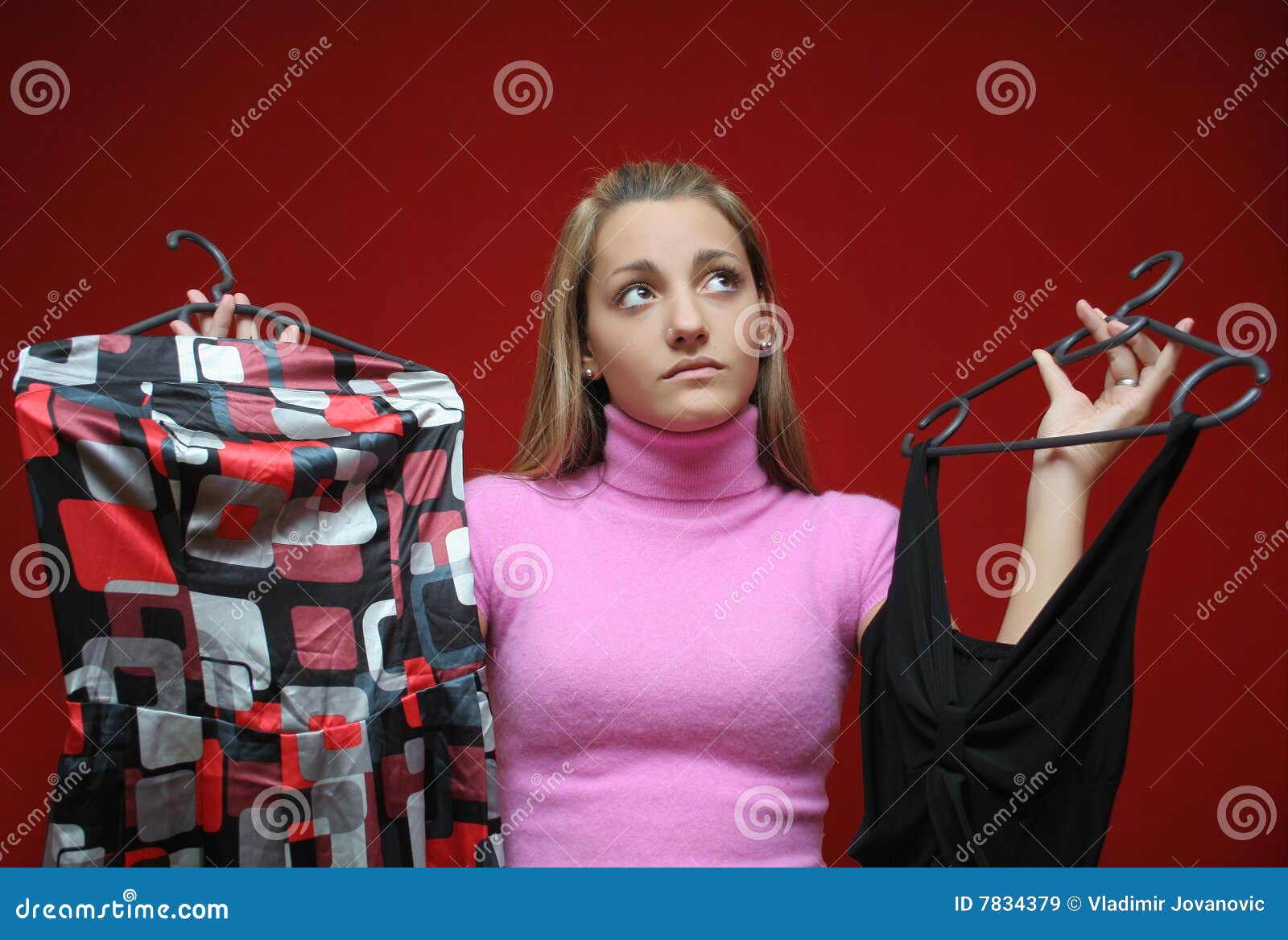 Teen and dresses. Teenage girl can not choose which dress to take for tonight party