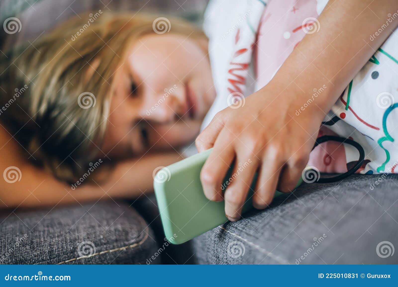 teen girl checking social media holding smartphone, relaxing on sofa