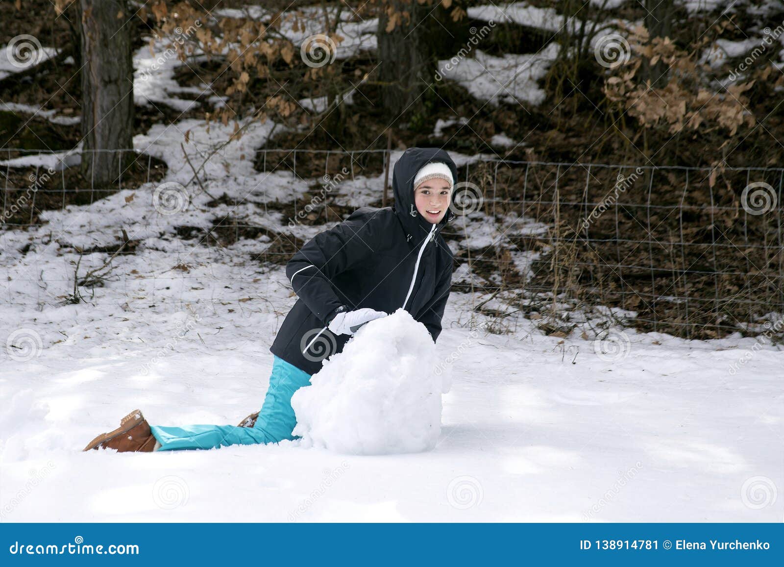 Teen Girl in Warm Winter Clothes Making a Snowman in the Forest Stock ...