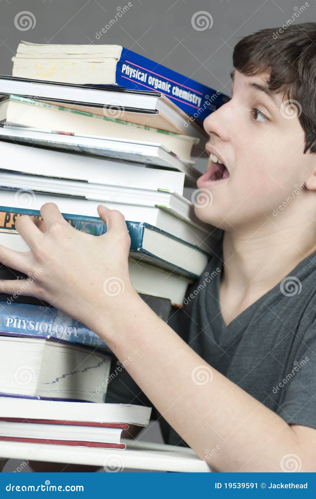 teen tries to carry unbalanced stack of textbooks
