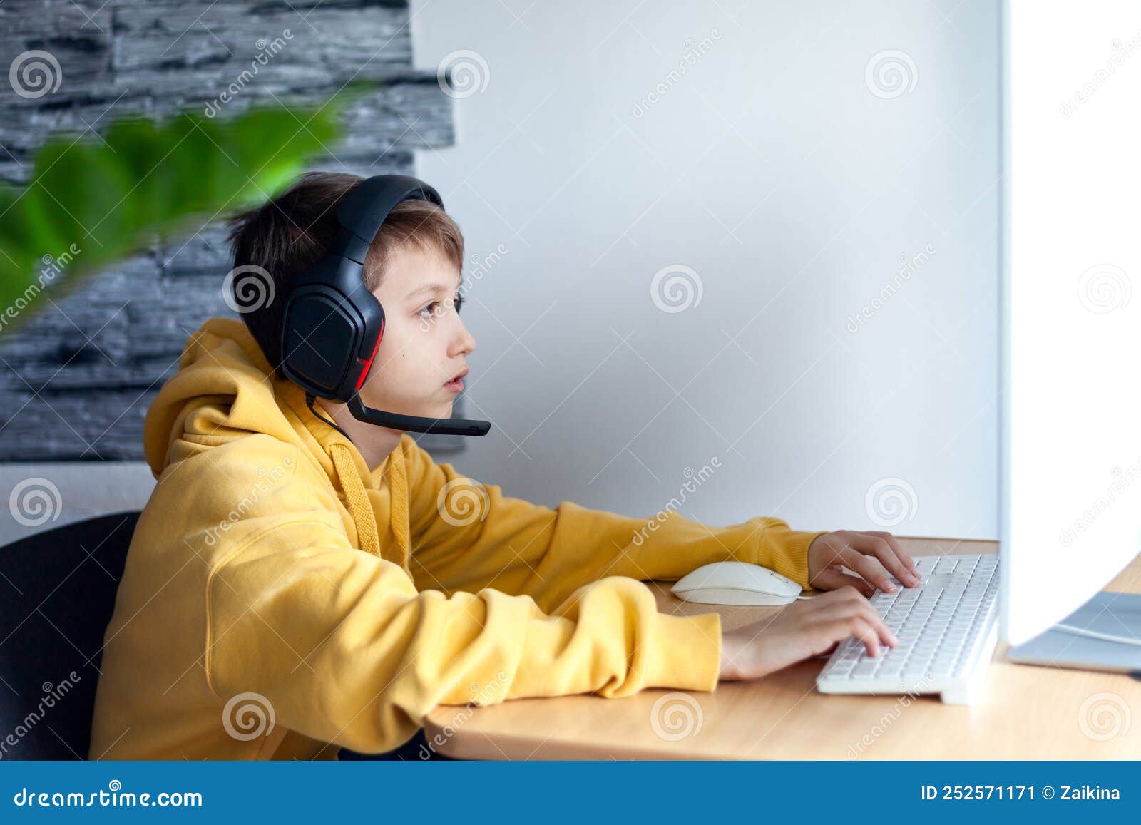 Teenager Boy Online Plays A Computer Game With Headphones And A