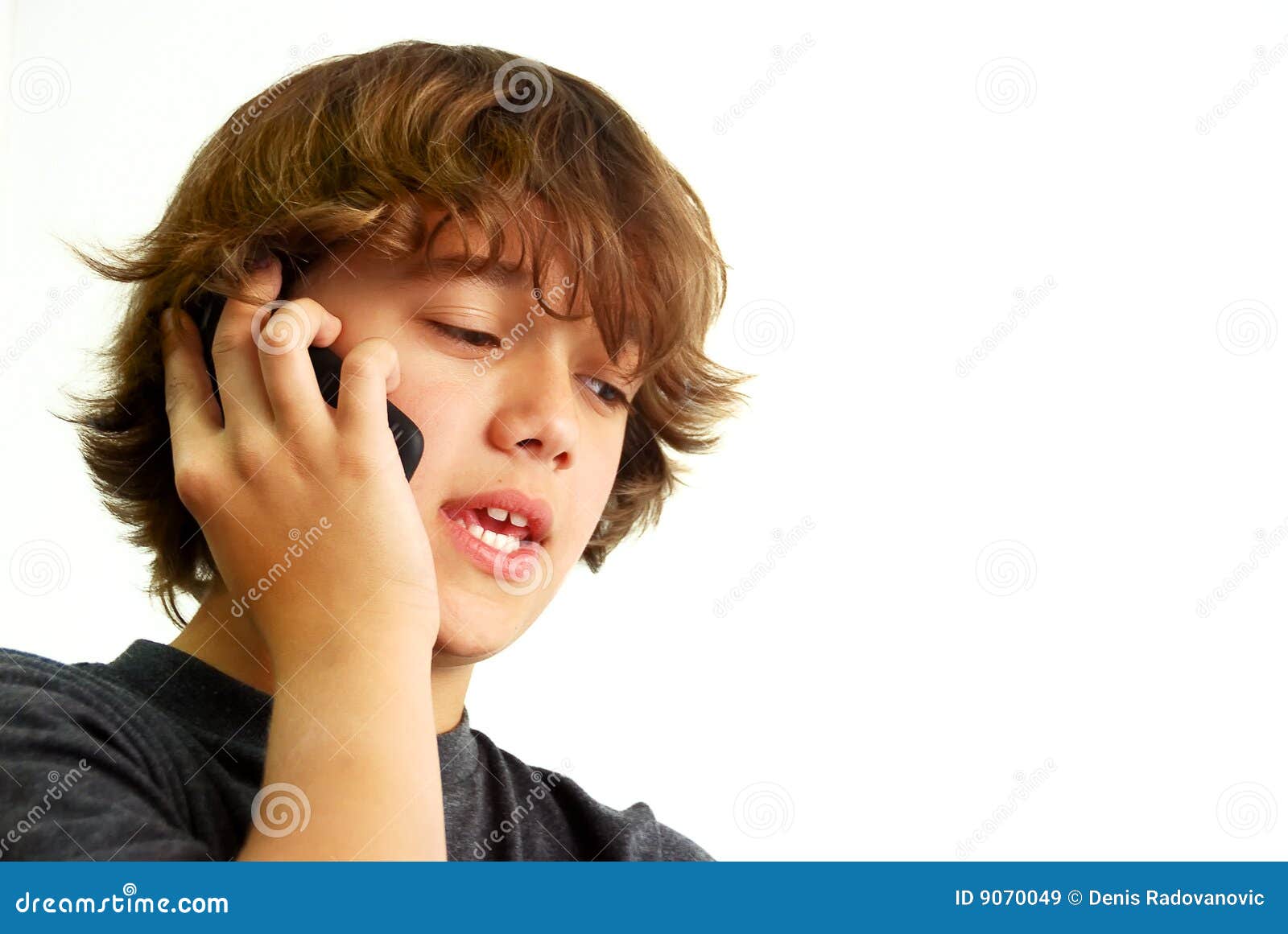 Teenage boy talking on mobile phone isolated on white background.