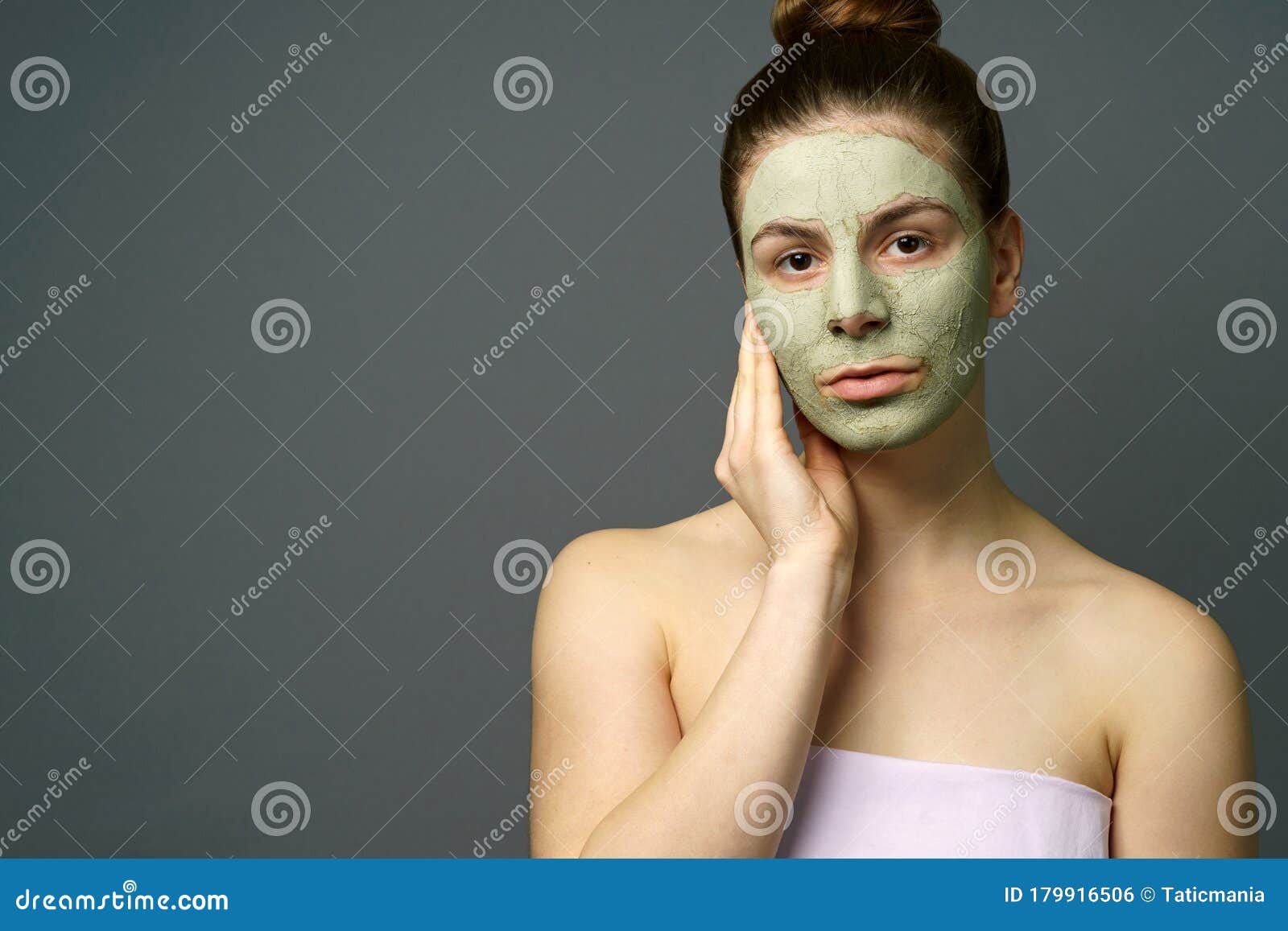 teenage girl with clay mask on her face and hand
