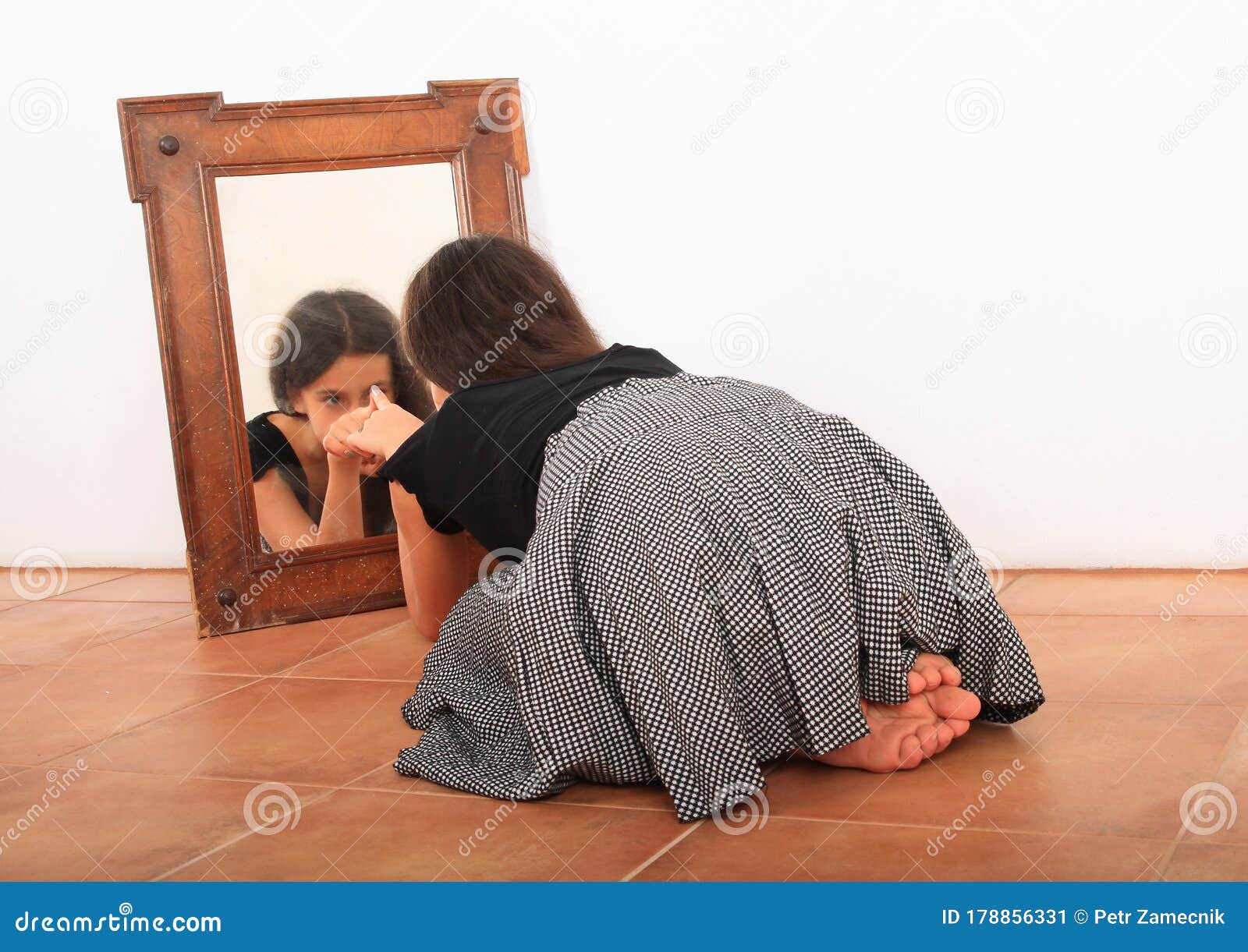 brunette girl watching herself in mirror