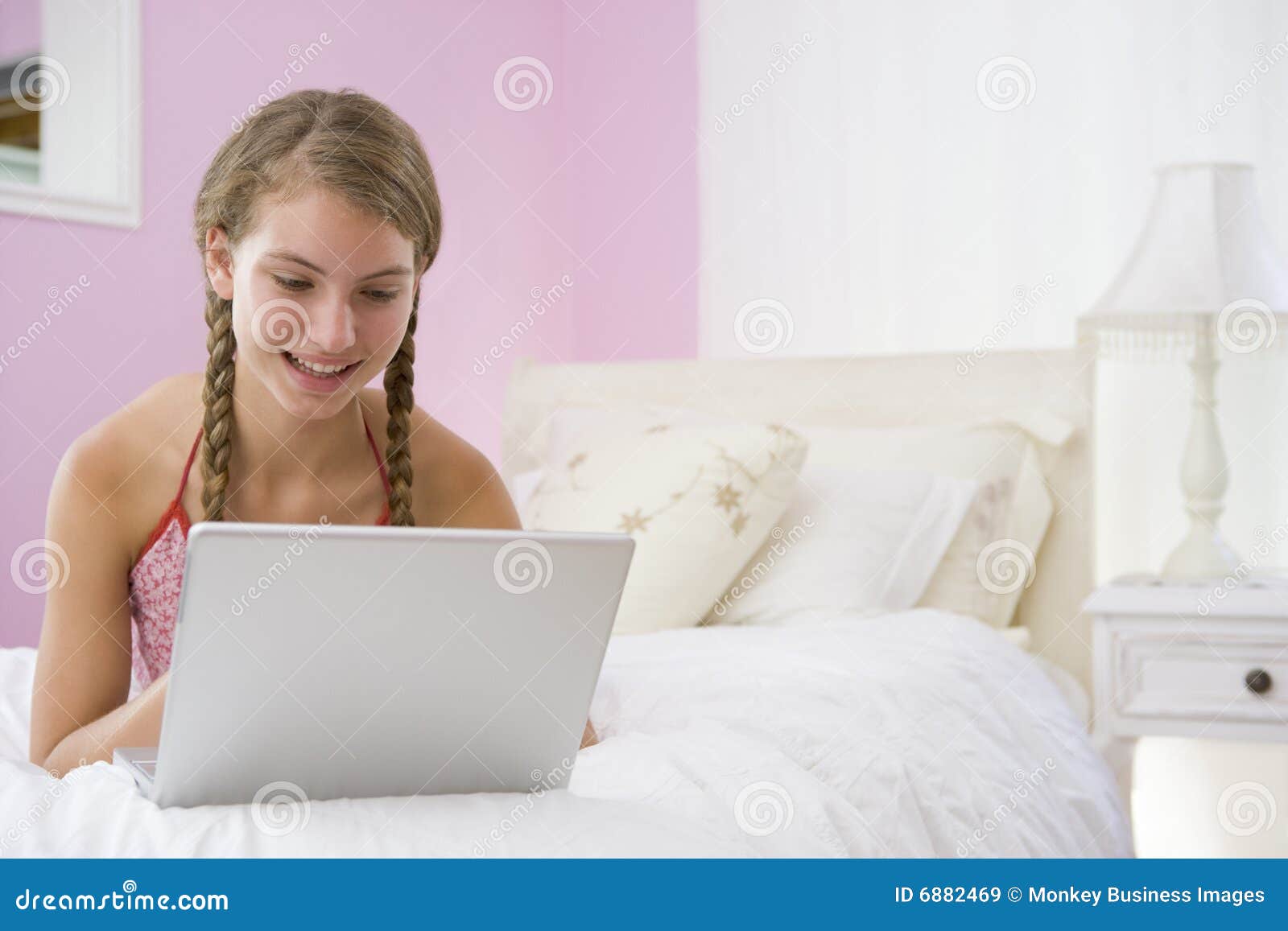 Teenage Girl Lying on Bed Using Laptop Stock Image Image of braids