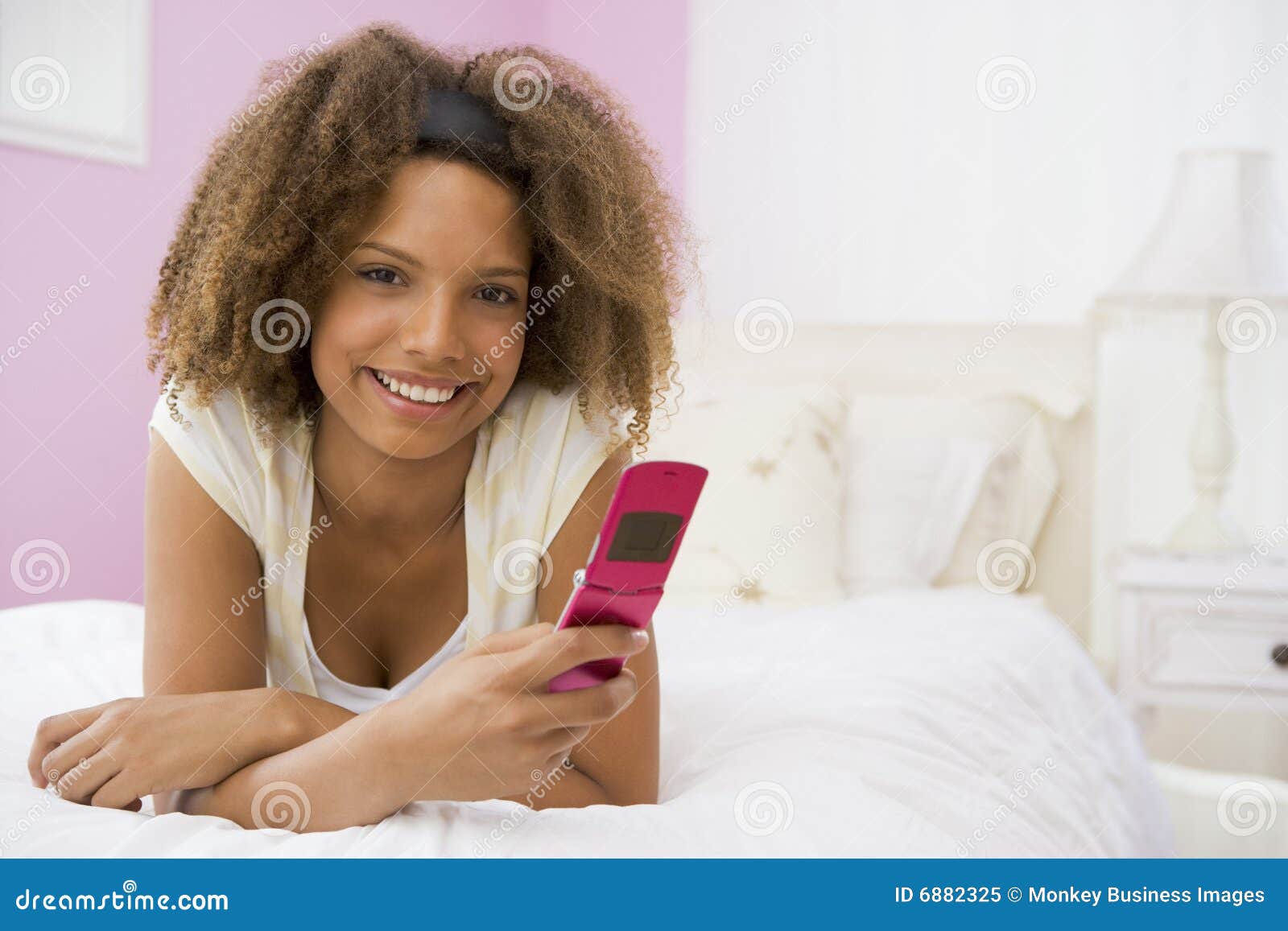 Teenage Girl Lying on Bed Using Mobile Phone Stock Image Image of