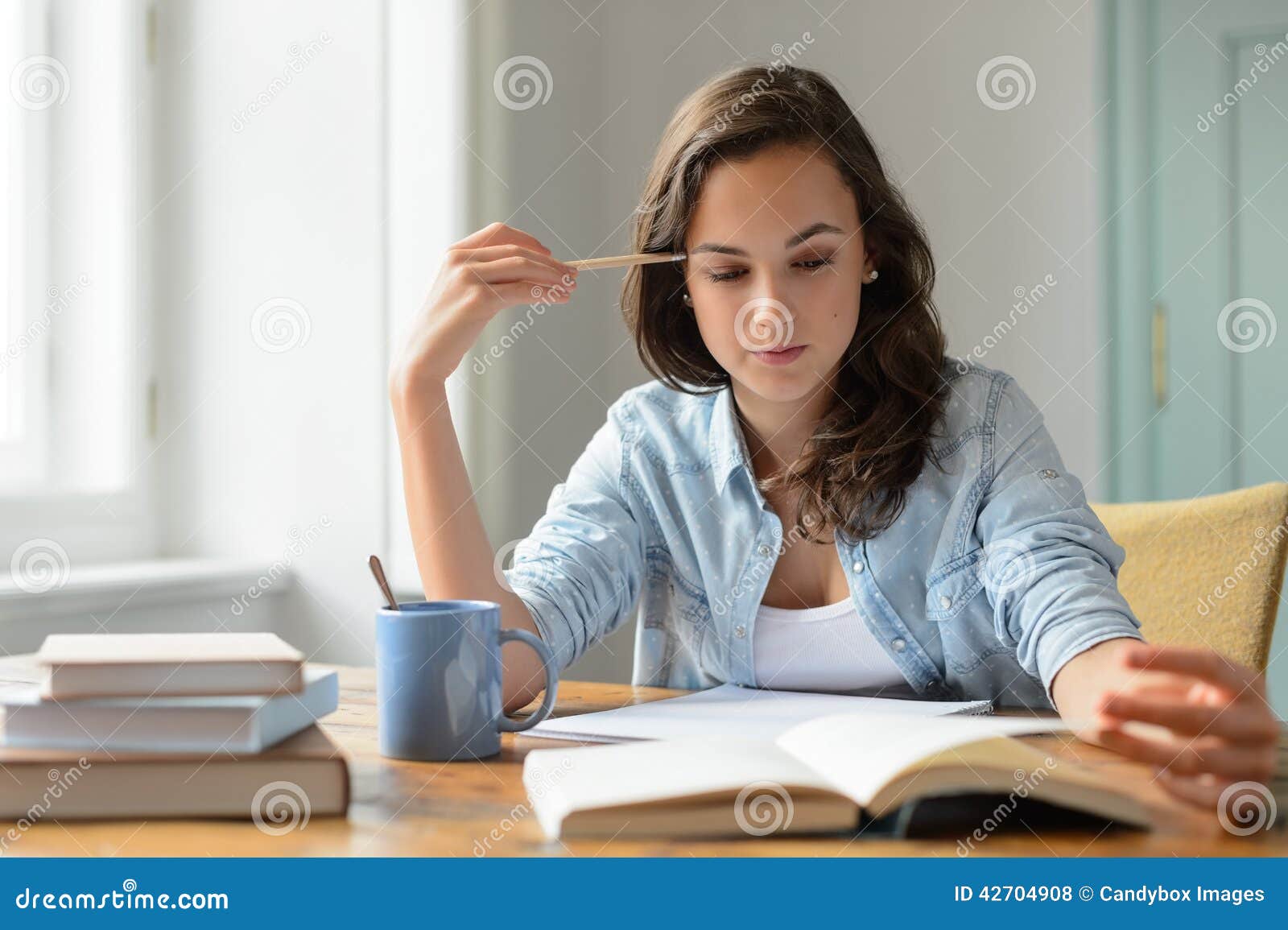 teenage girl studying reading book at home