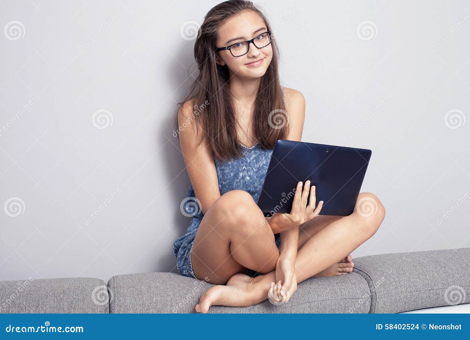 Teen woman girl using a tablet pc assis sur le sol dans un salon , touchant  un écran blanc 4827369 Photo de stock chez Vecteezy