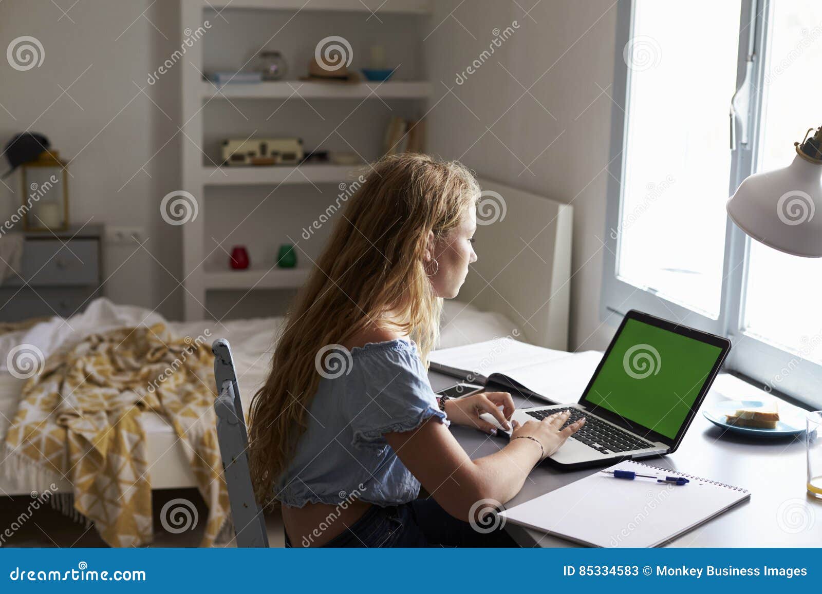 Teenage Girl Using Laptop Computer At A Desk In Her Bedroom Stock