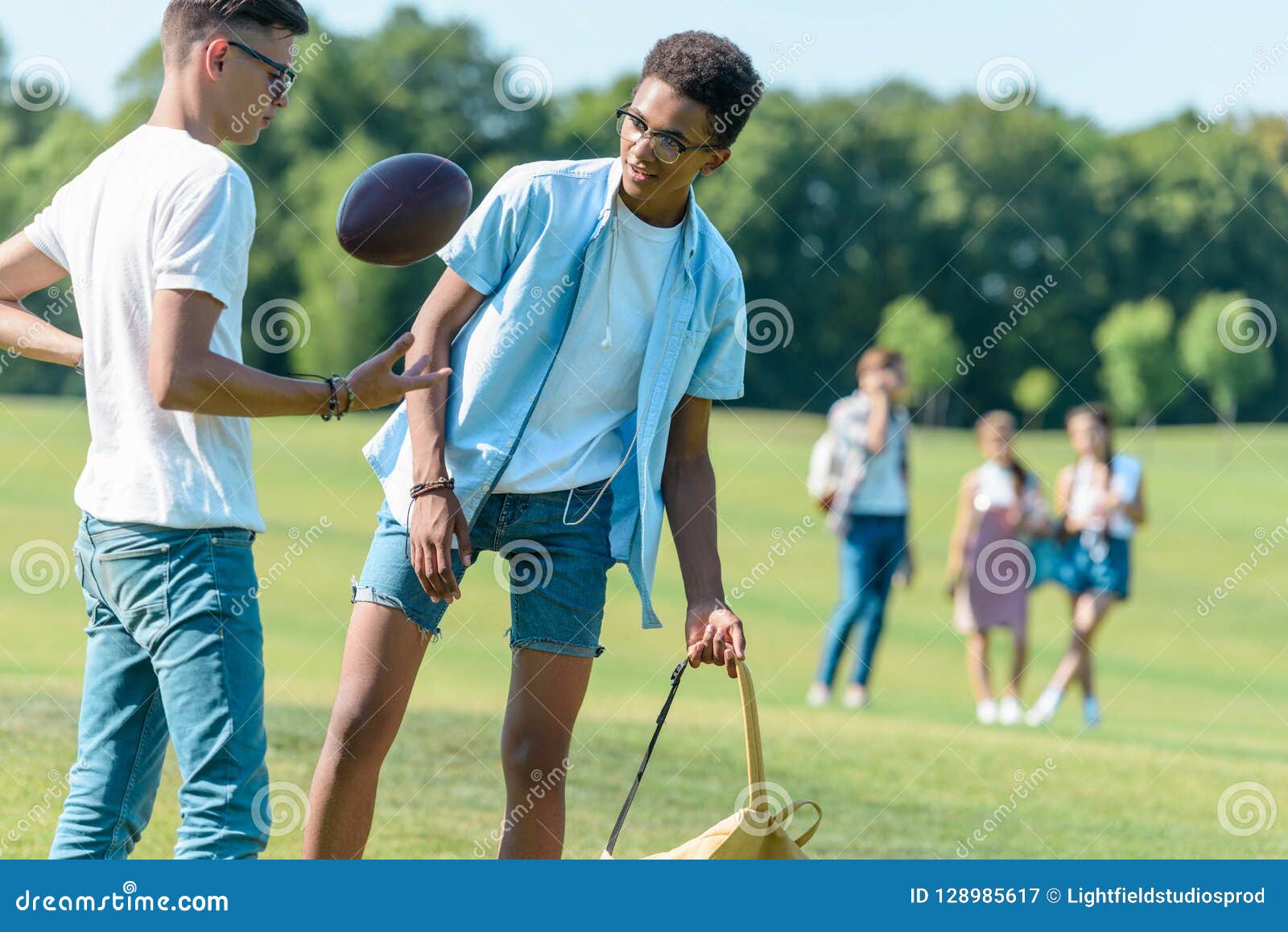 Teenage Multiethnic Friends Playing with Rugby Ball while Classmates ...
