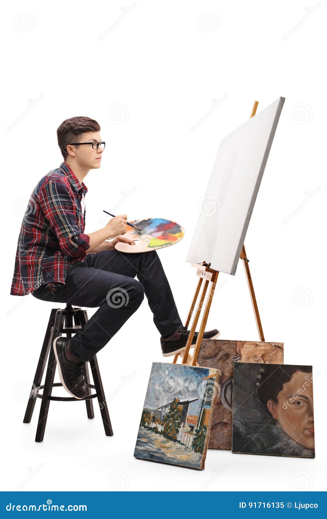 Teenage Painter with Paintbrush and Palette Looking at Canvas Stock