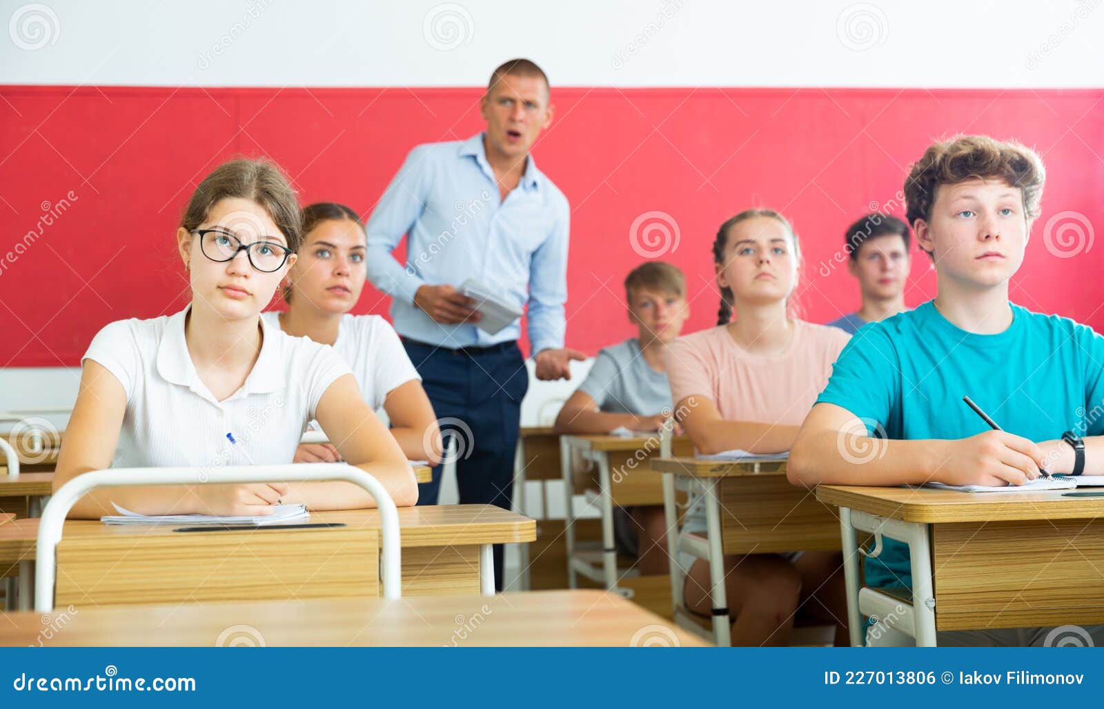 Teenage Students are Sitting at Their Desks in Classroom. in Background the  Teacher Stock Photo - Image of activity, classroom: 227013806