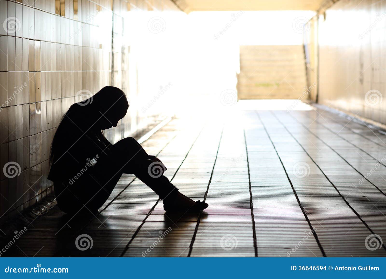 teenager depressed sitting inside a dirty tunnel