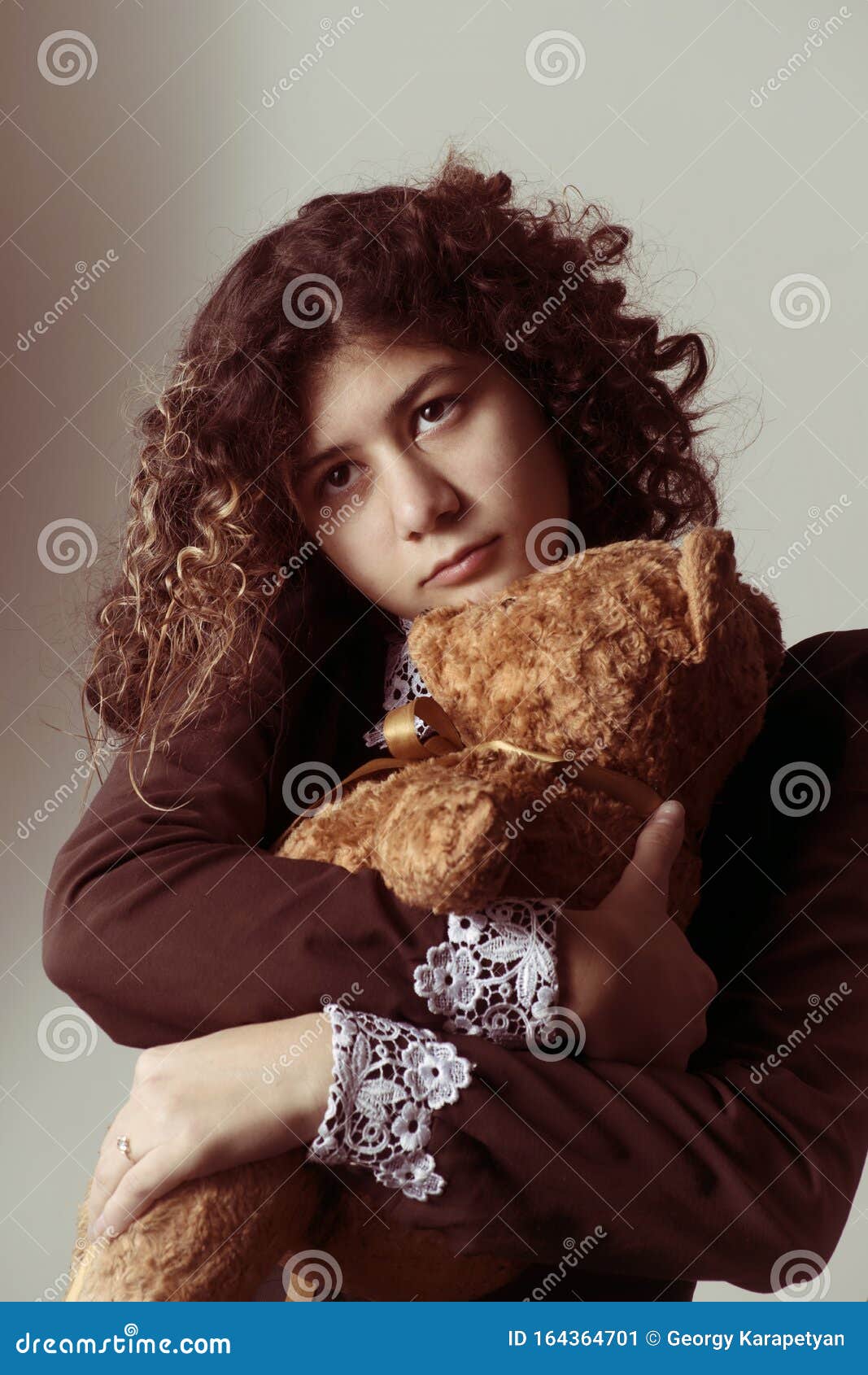 Teenager Girl with Curly Hair in a School Uniform in Retro Style with an  Old Teddy Bear in Her Arms, with a Pensive Face Stock Image - Image of  beauty, brunette: 164364701