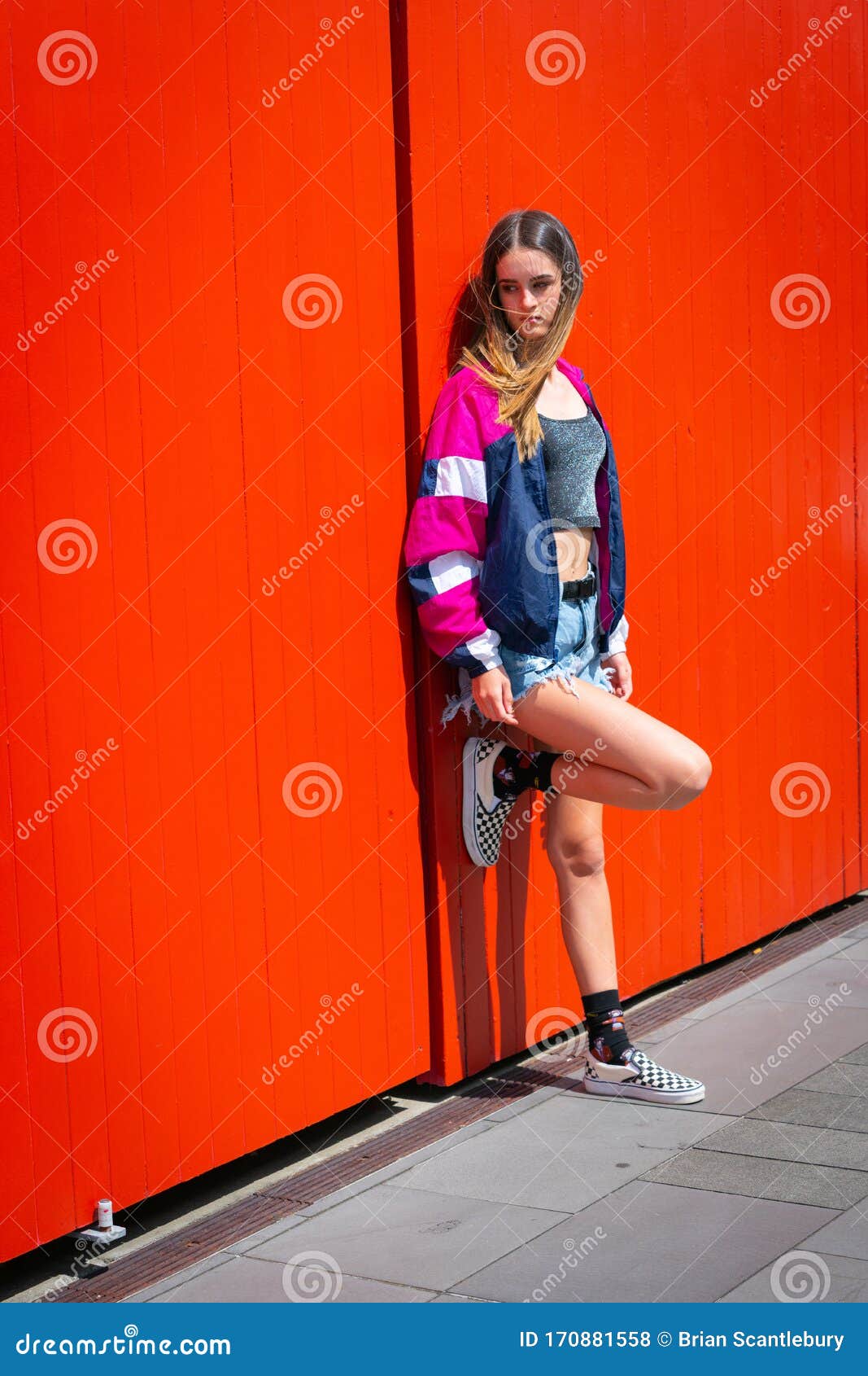 Teenager Girl Standing and Leaning Against Bright Orange Doors Stock ...