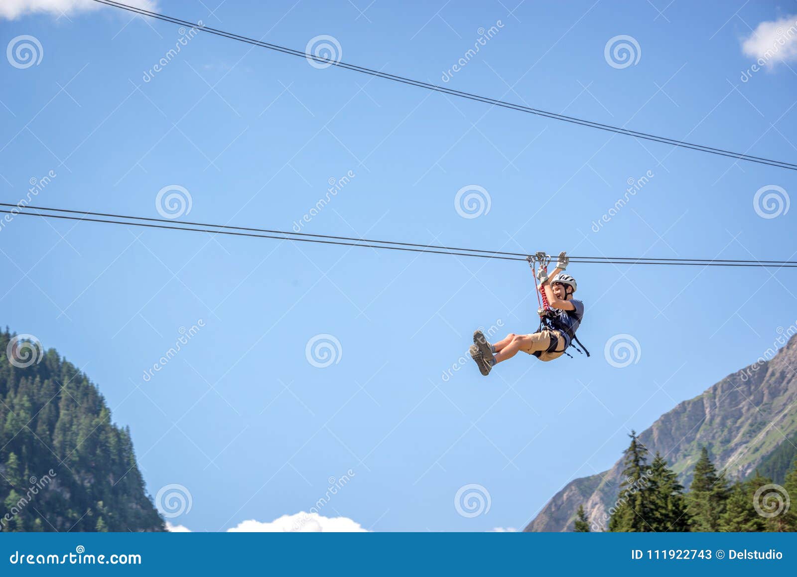 teenager having fun on a zip line in the alps, adventure, climbing, via ferrata during vacations in summer