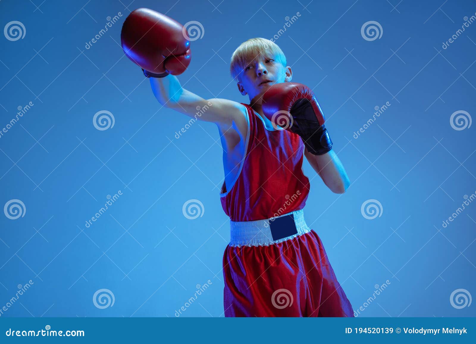 Teenager in Sportswear Boxing Isolated on Blue Studio Background in ...