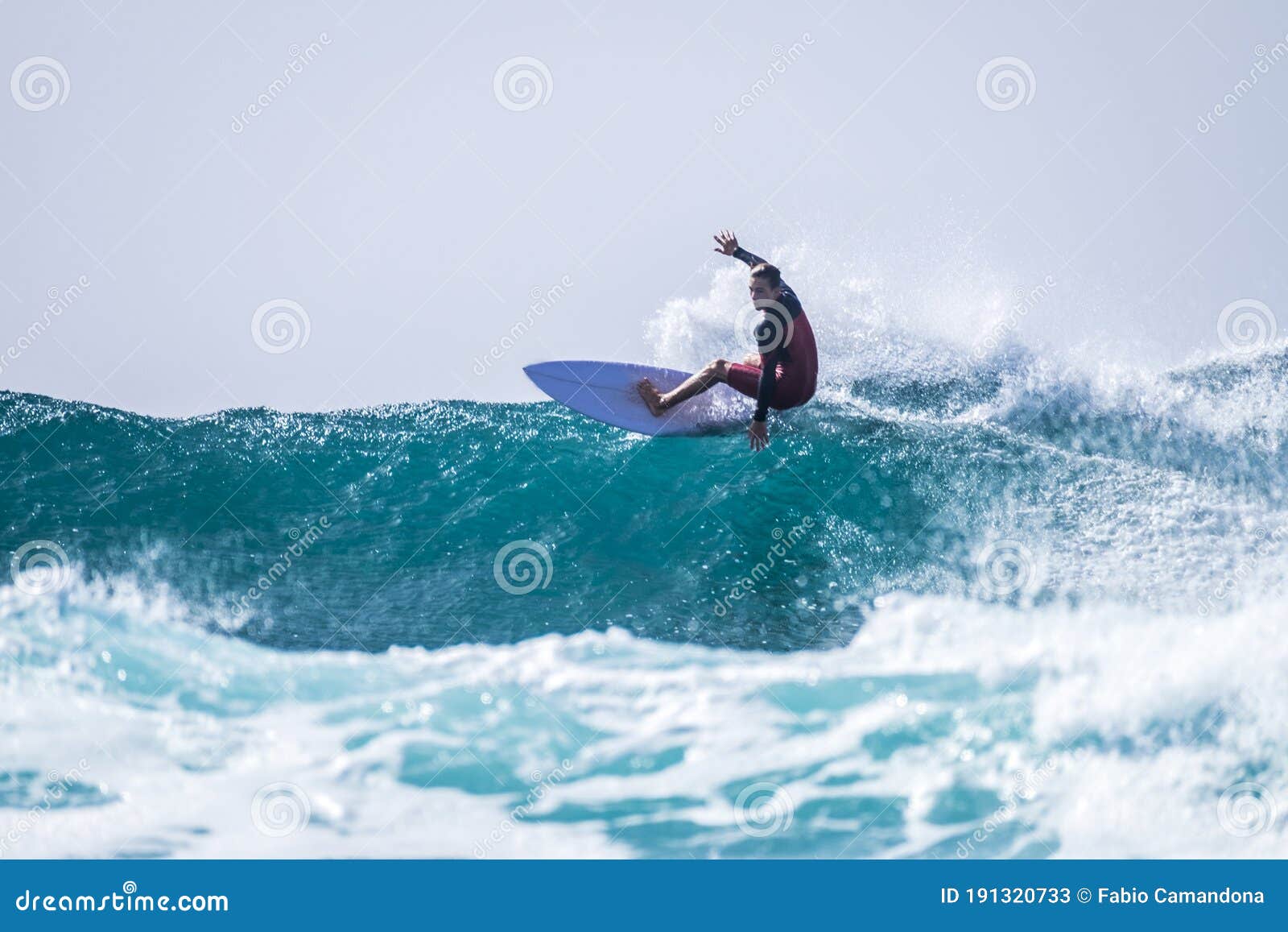 teenager surfing at the wave in tenerife playa de las americas - red wetsuits and beautiful and perfect wave