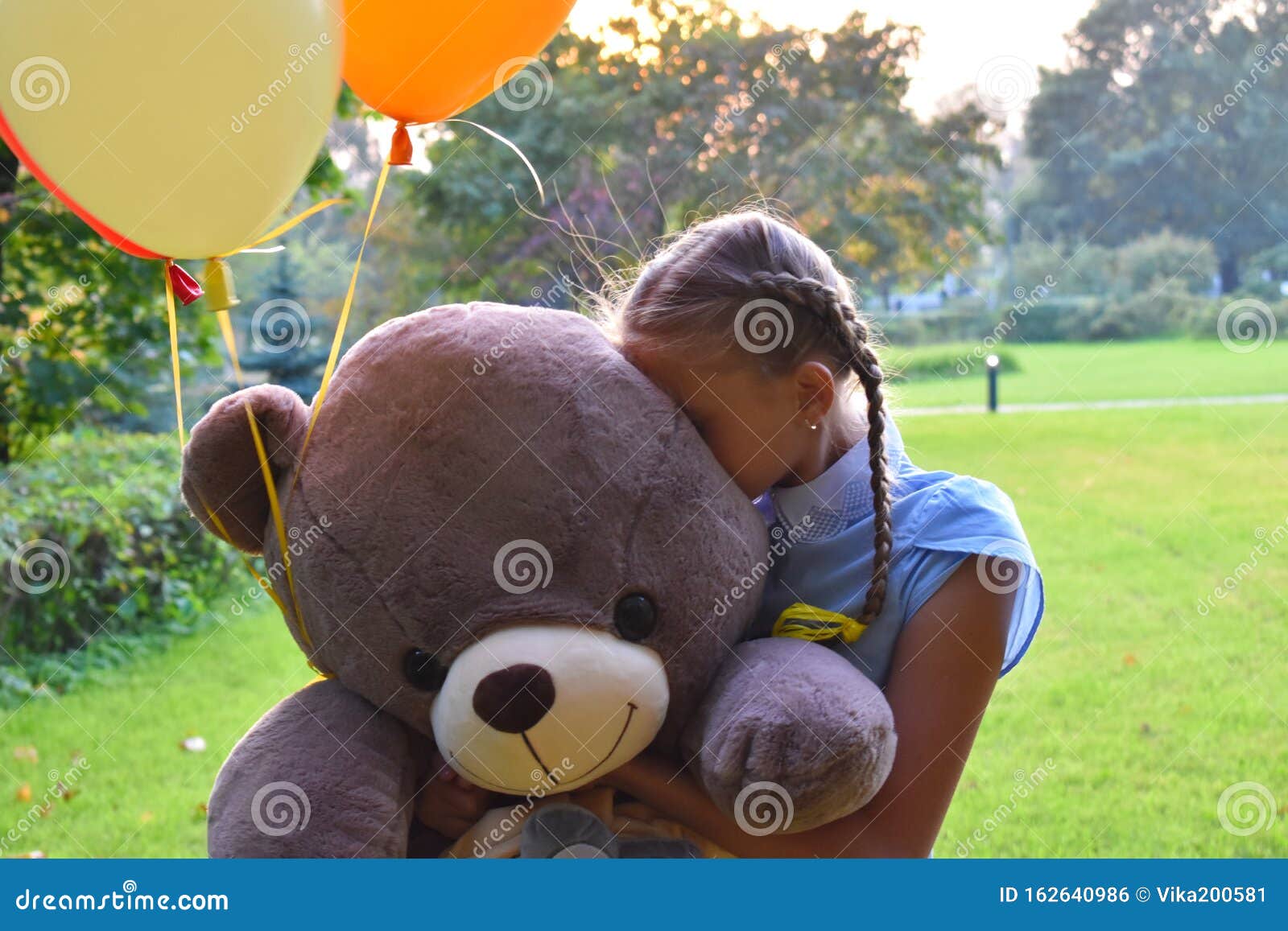 girl hugging giant teddy bear